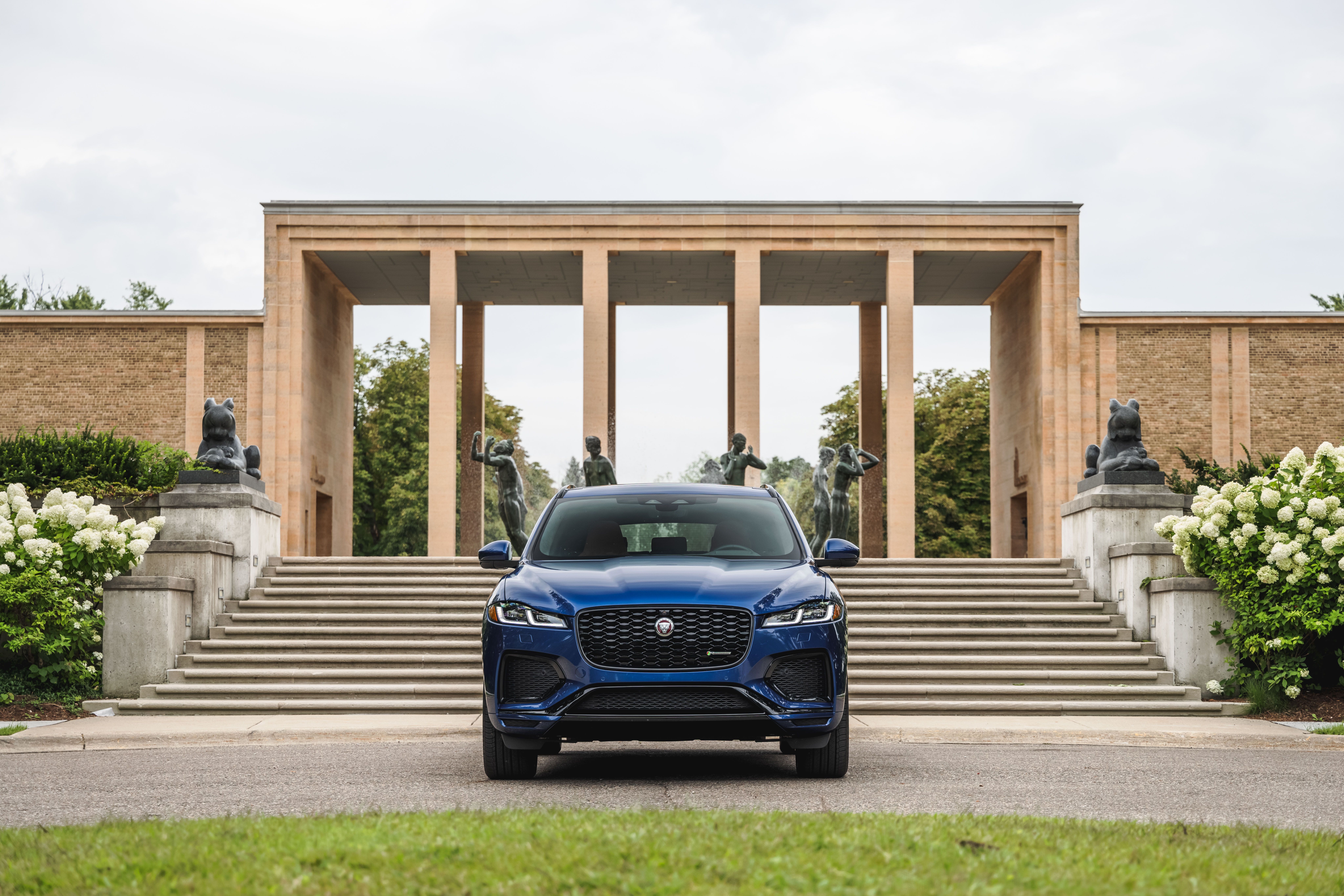 Blue Jaguar F-Pace SUV in front of a grand building HD Wallpaper