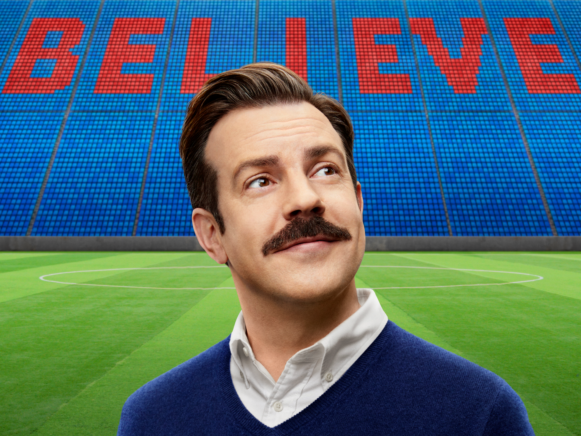 Ted Lasso with BELIEVE sign in stadium HD Wallpaper