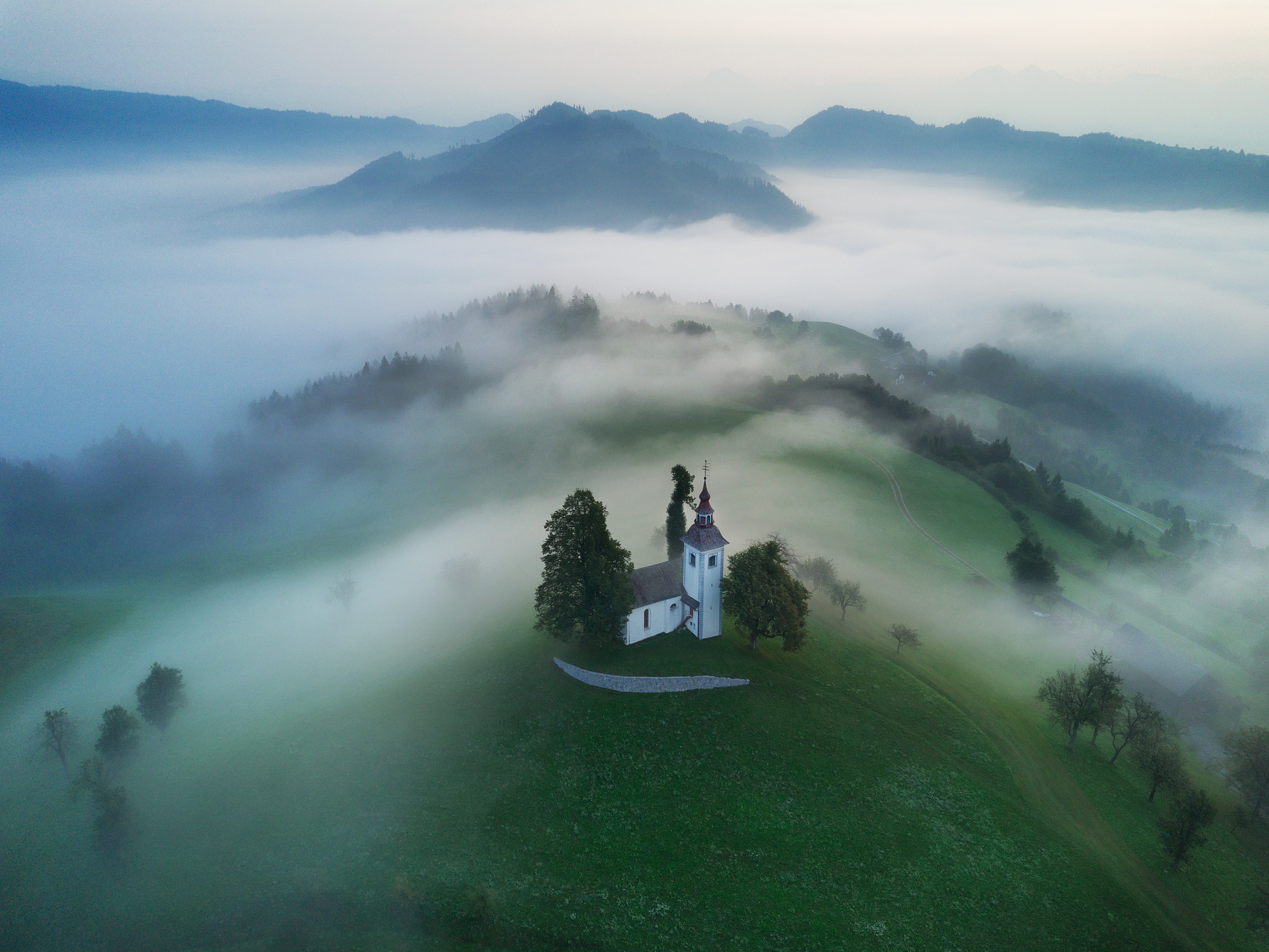 Sveti Tomaž church on a foggy Slovenian hilltop HD Wallpaper
