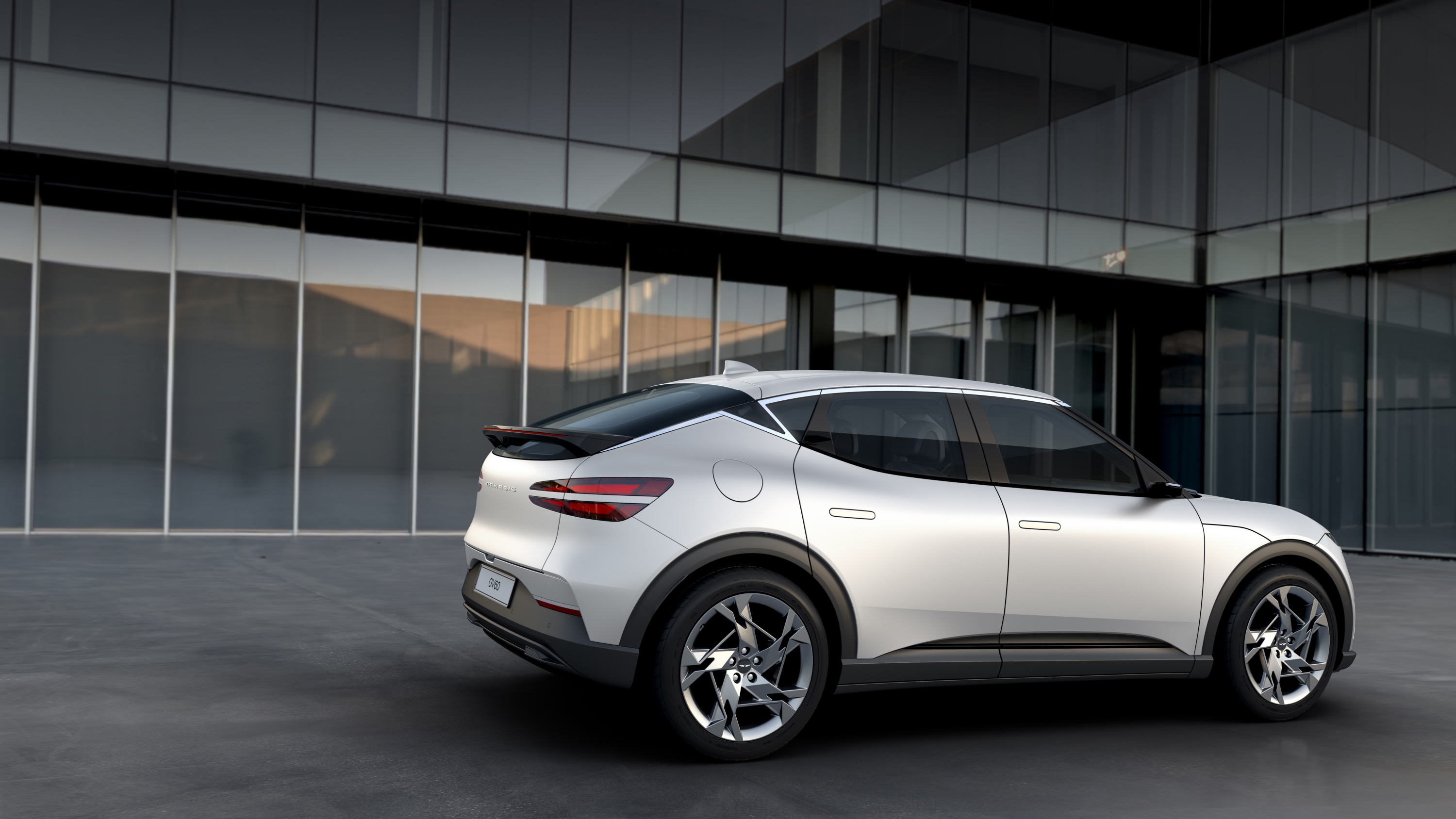 Genesis GV60 SUV parked outside modern building HD Wallpaper