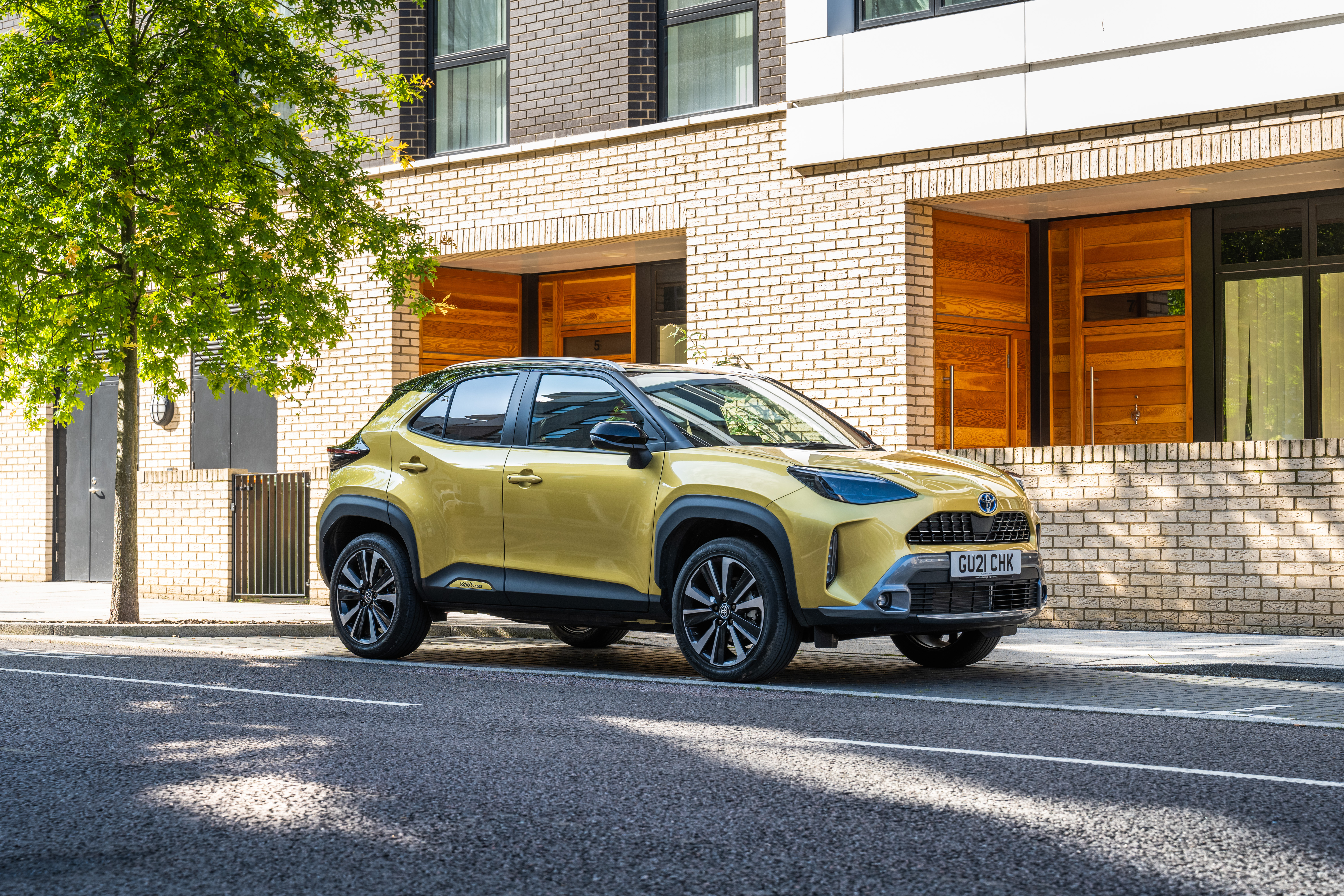 Yellow Toyota Yaris Cross Hybrid SUV on street HD Wallpaper