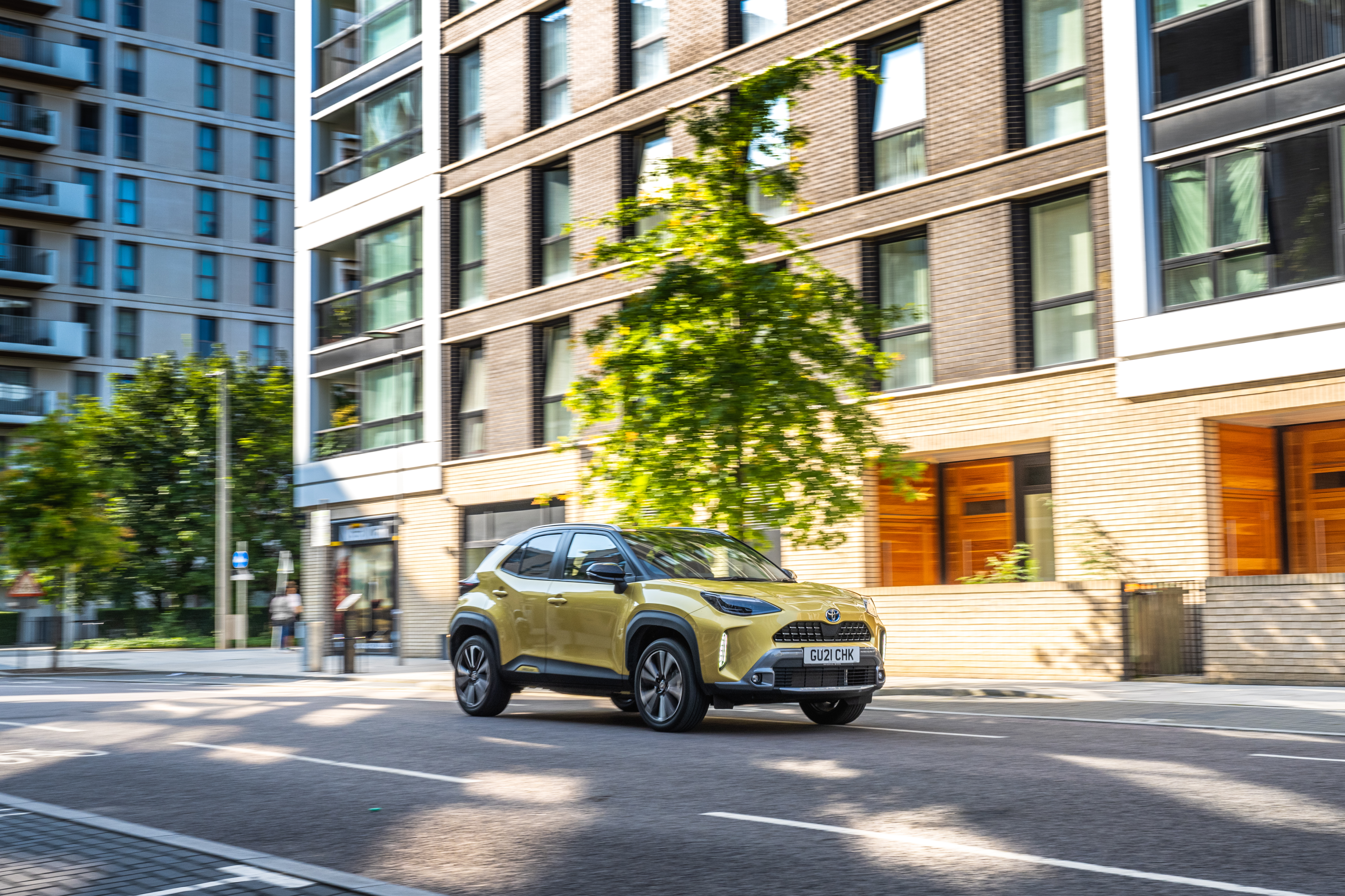 Yellow Toyota Yaris Cross Hybrid SUV on urban street HD Wallpaper