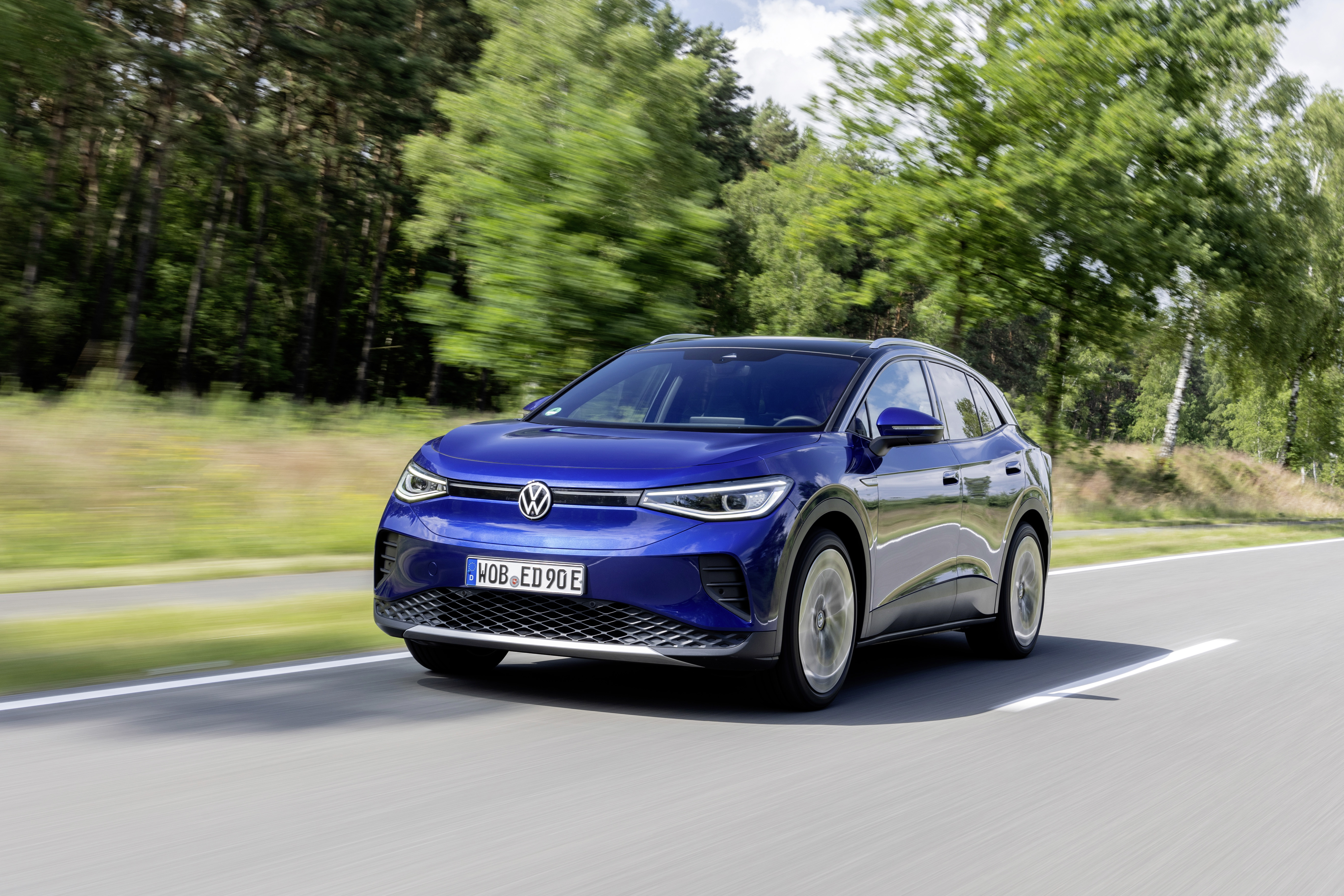 Blue Volkswagen ID.4 Pro Electric Car driving on road HD Wallpaper