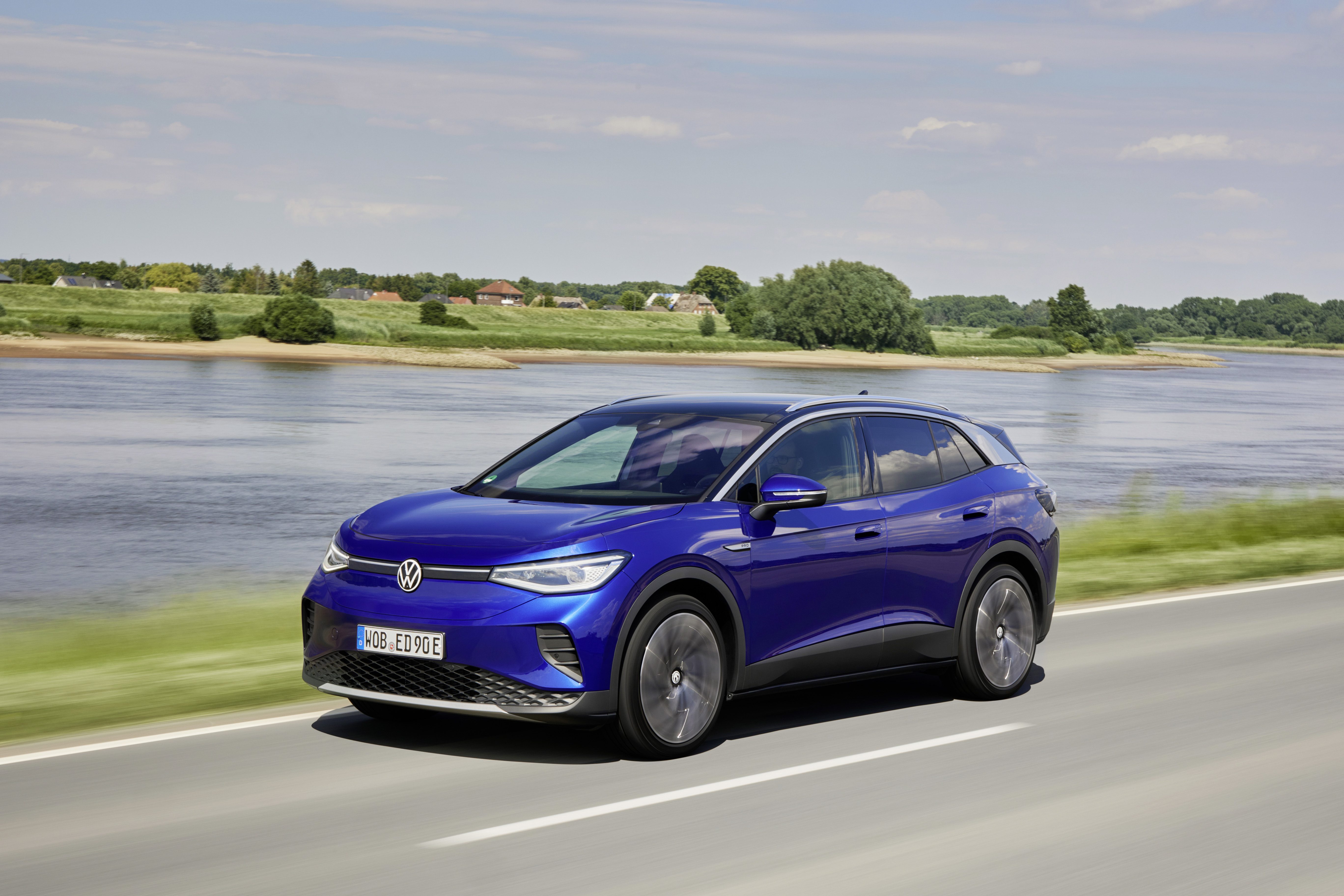 Blue Volkswagen ID.4 Electric Car Driving by a River HD Wallpaper