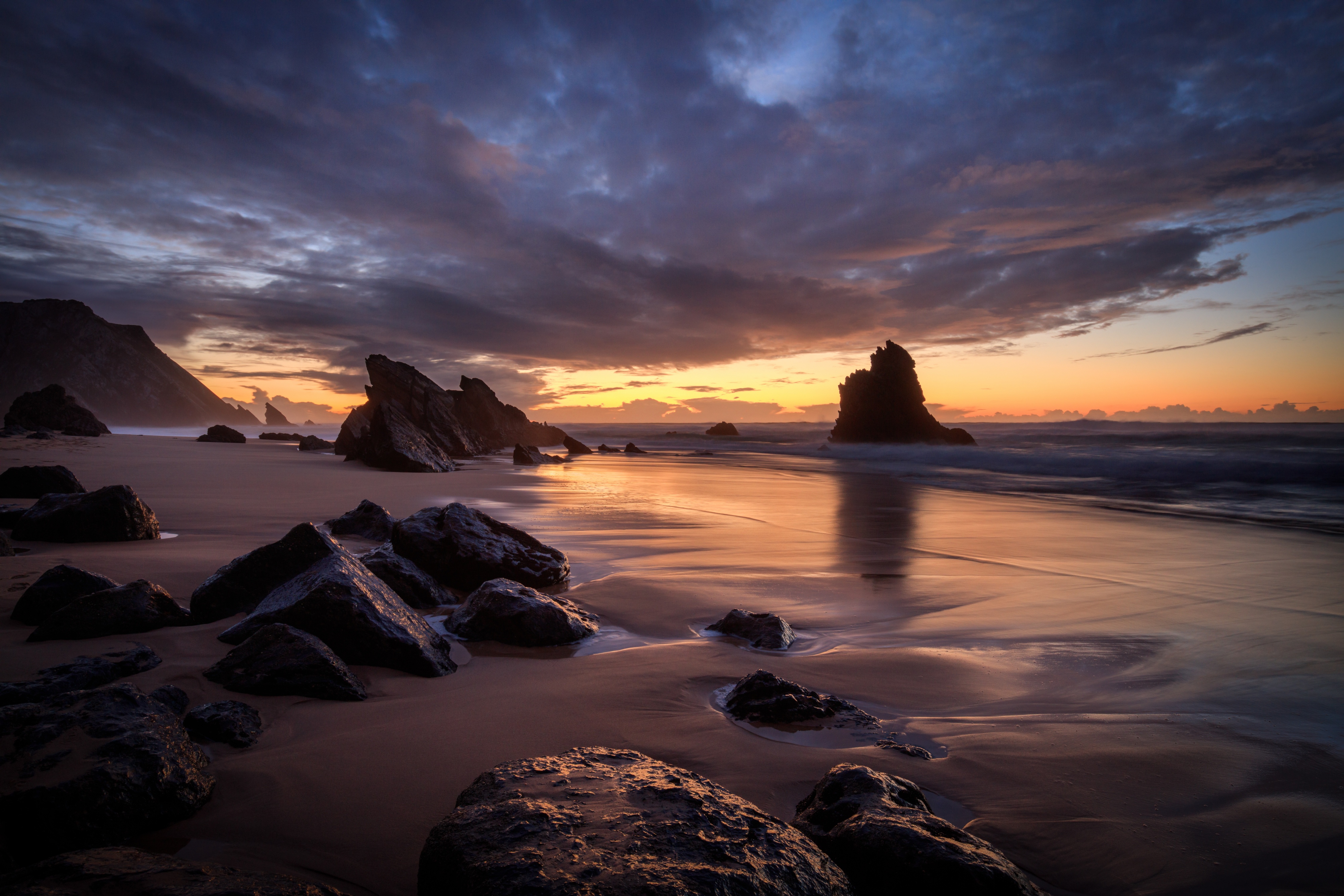 Dramatic sunset over a rocky beach HD Wallpaper