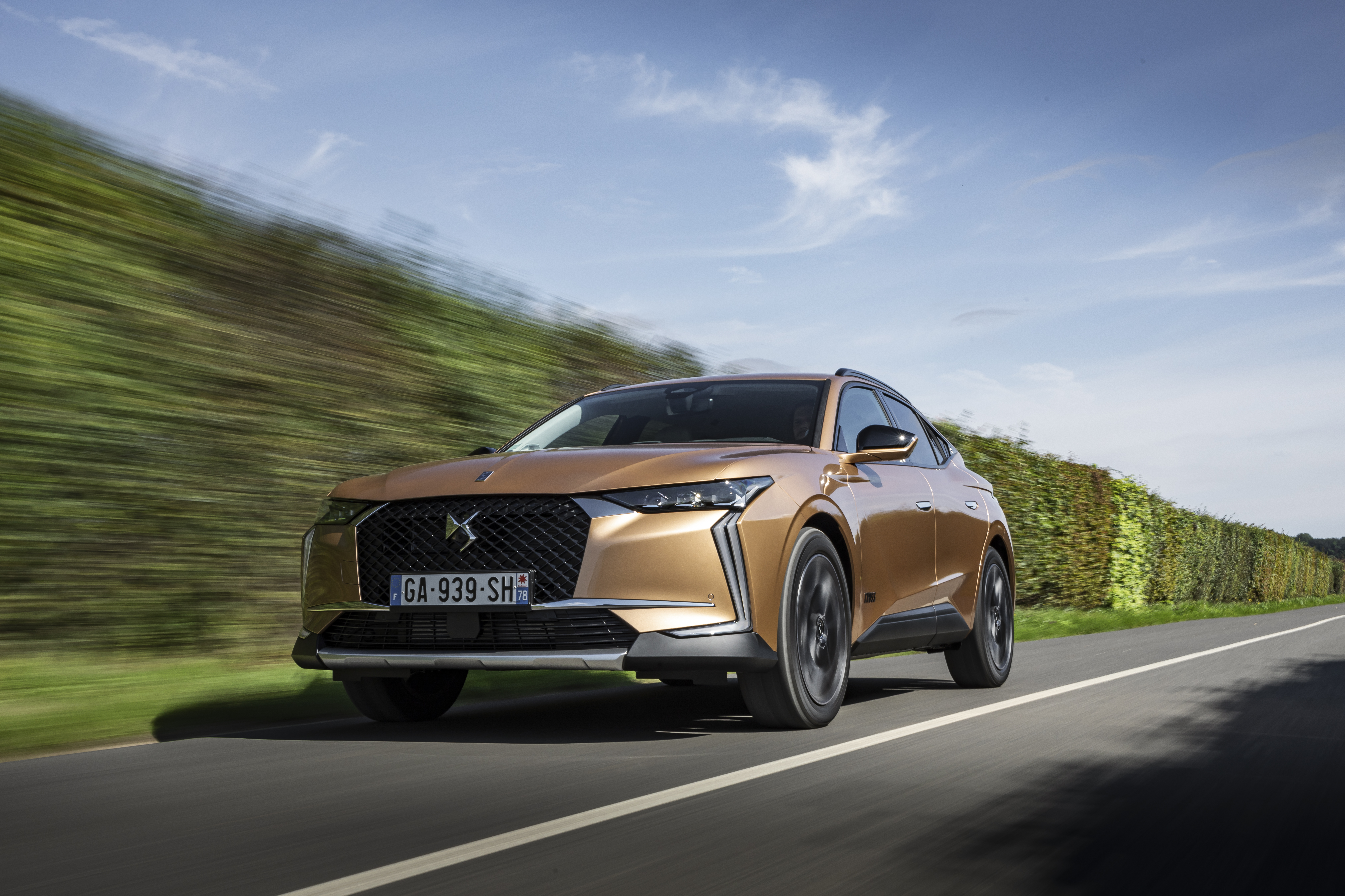 Golden DS 4 Cross SUV driving on a road HD Wallpaper