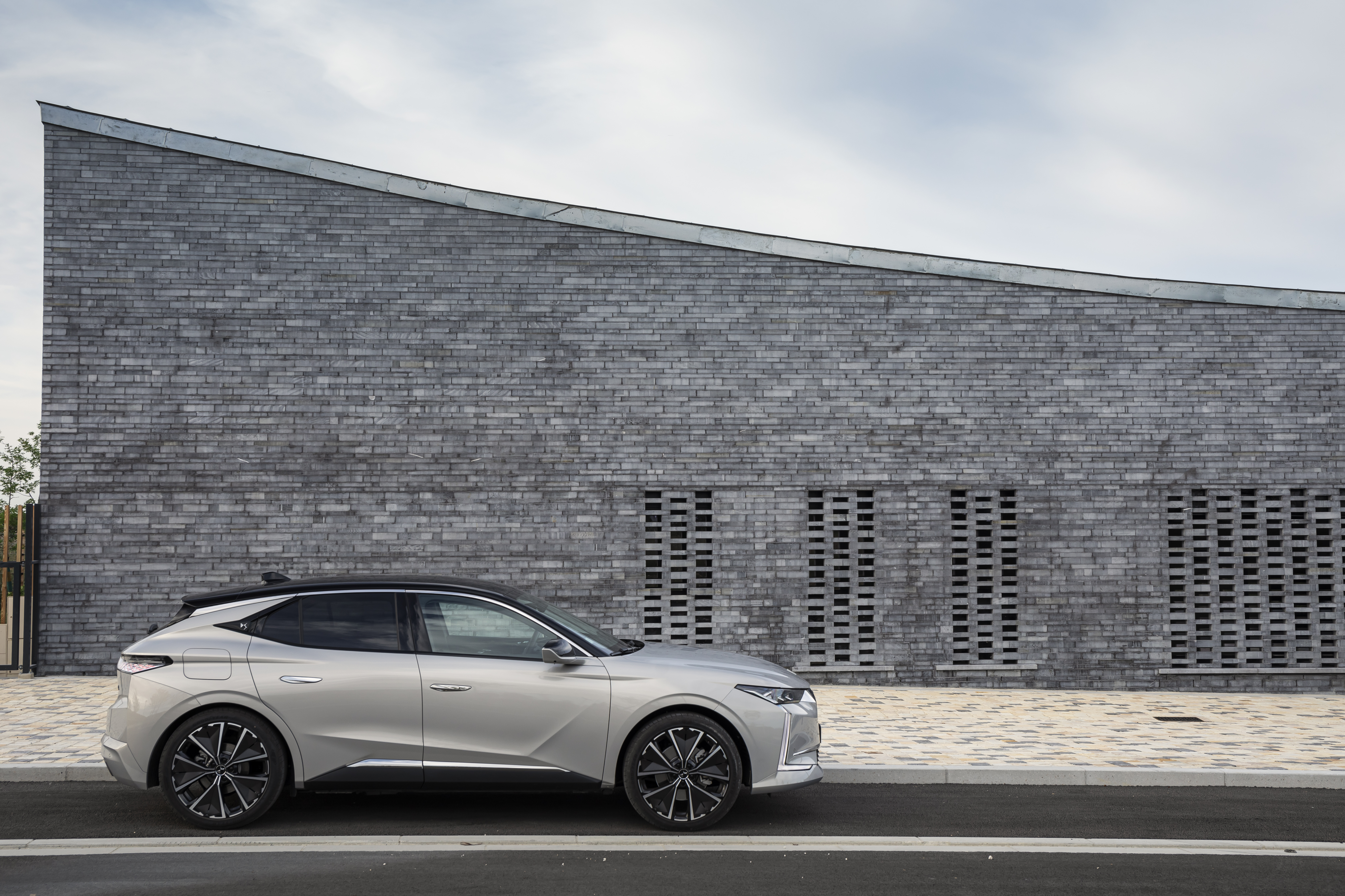 DS 4 E-Tense electric car by a modern brick building HD Wallpaper