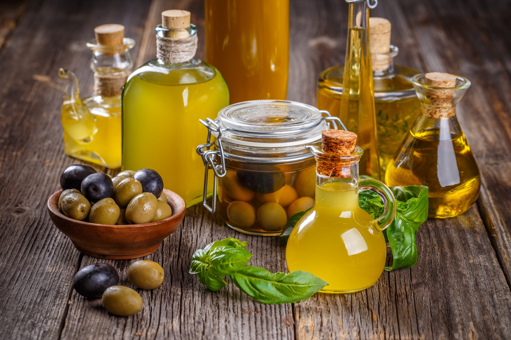 Fresh olive oil and olives with basil on wood HD Wallpaper