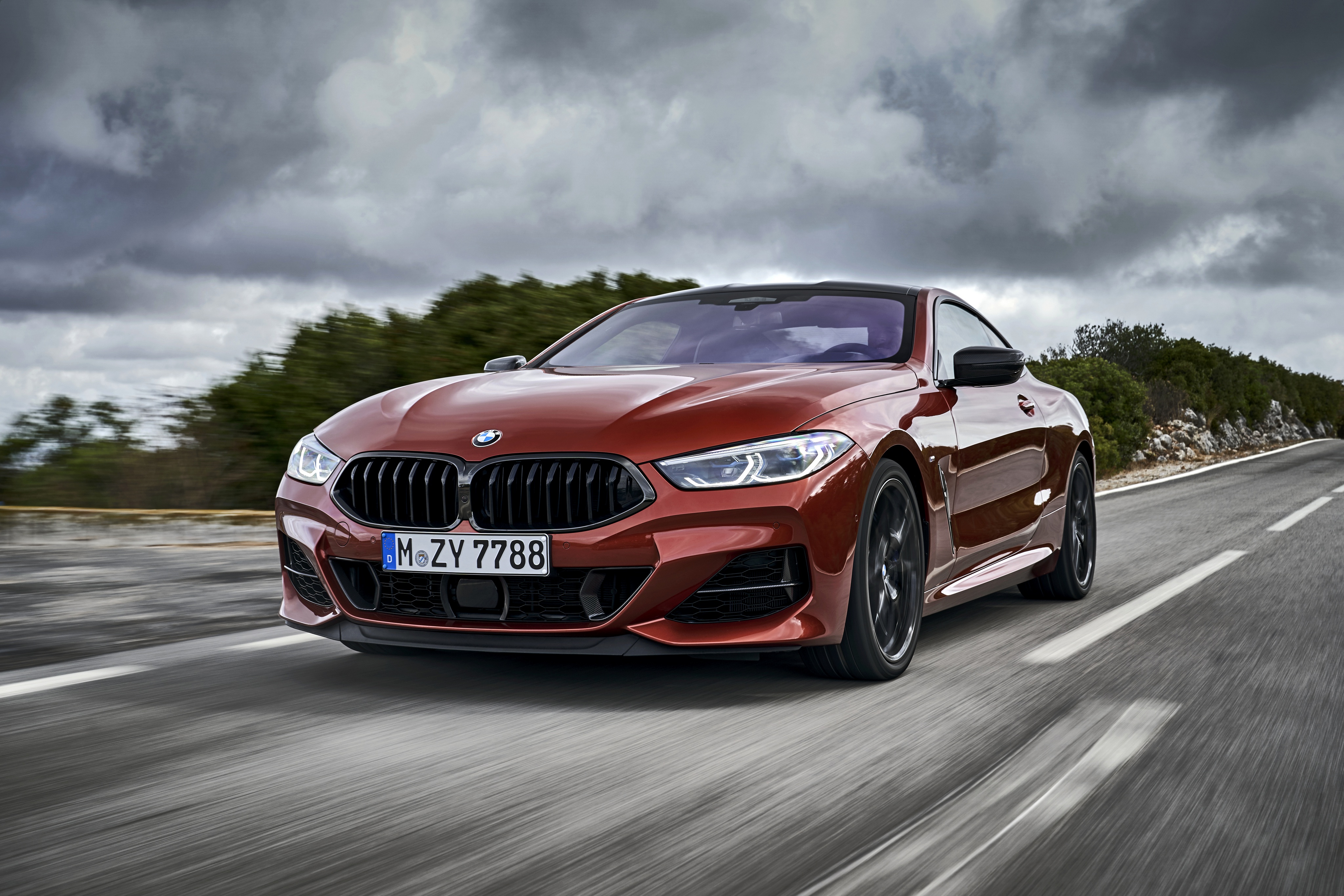 Dynamic Red BMW M850i Luxury Car on Winding Road HD Wallpaper