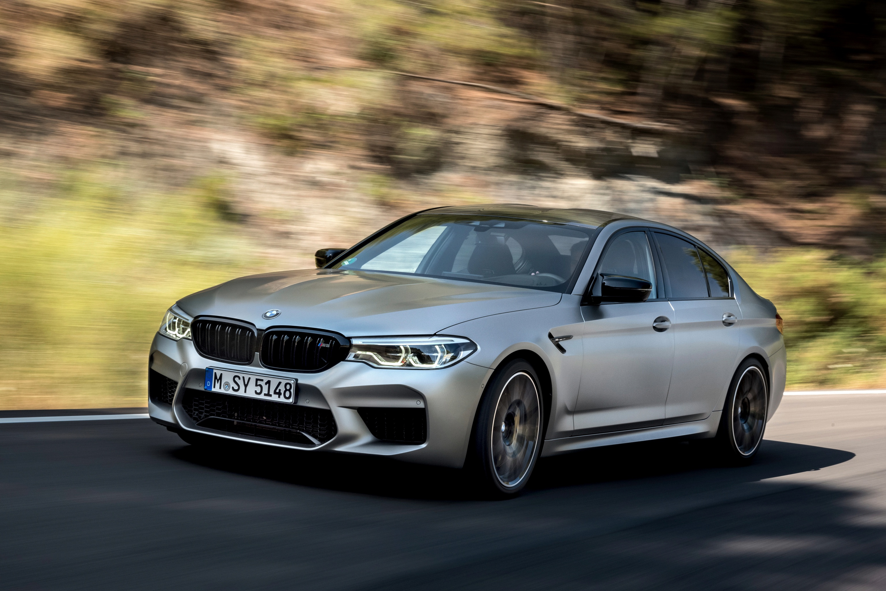 BMW M5 Competition driving fast on a road HD Wallpaper