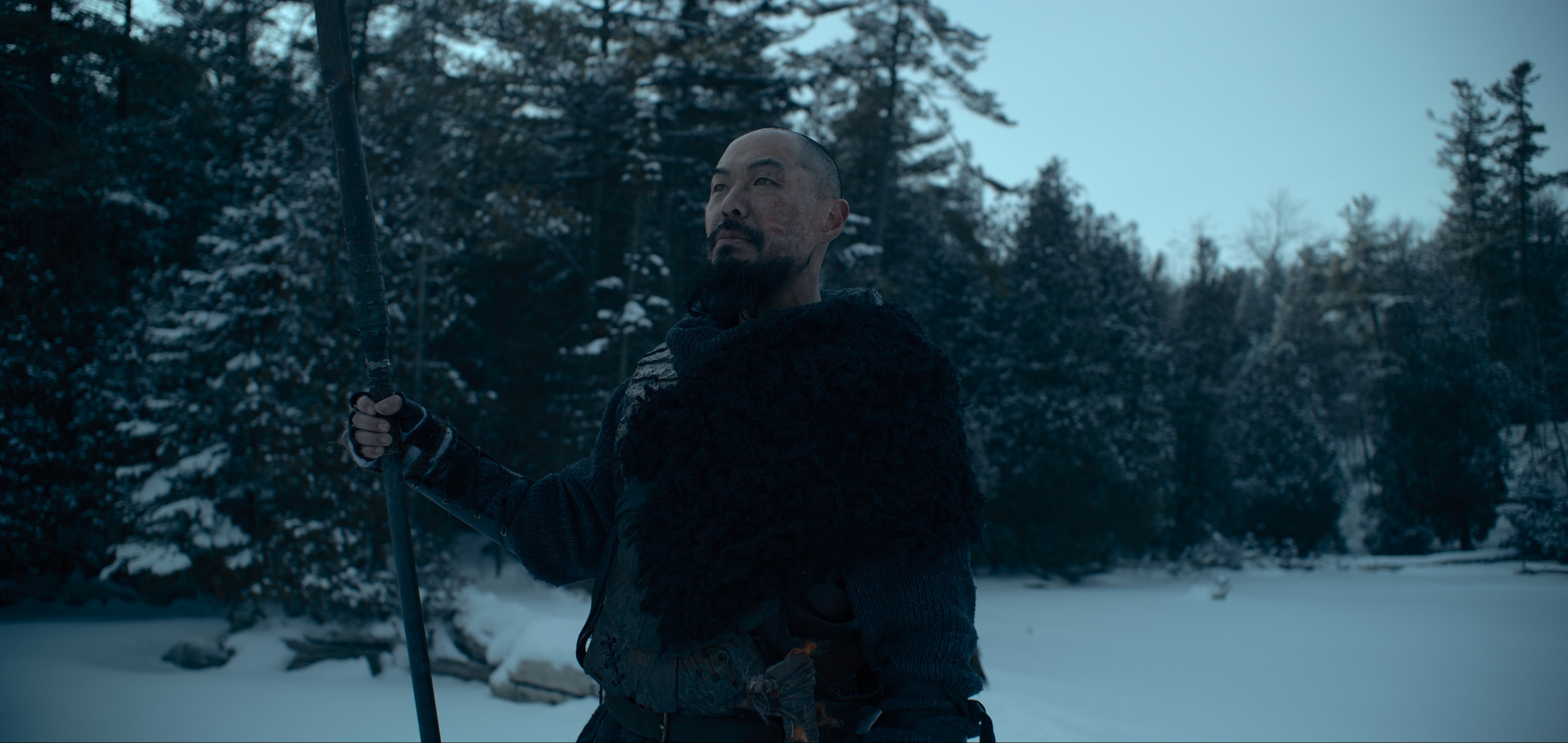 Hoon Lee in a snowy forest with a staff HD Wallpaper