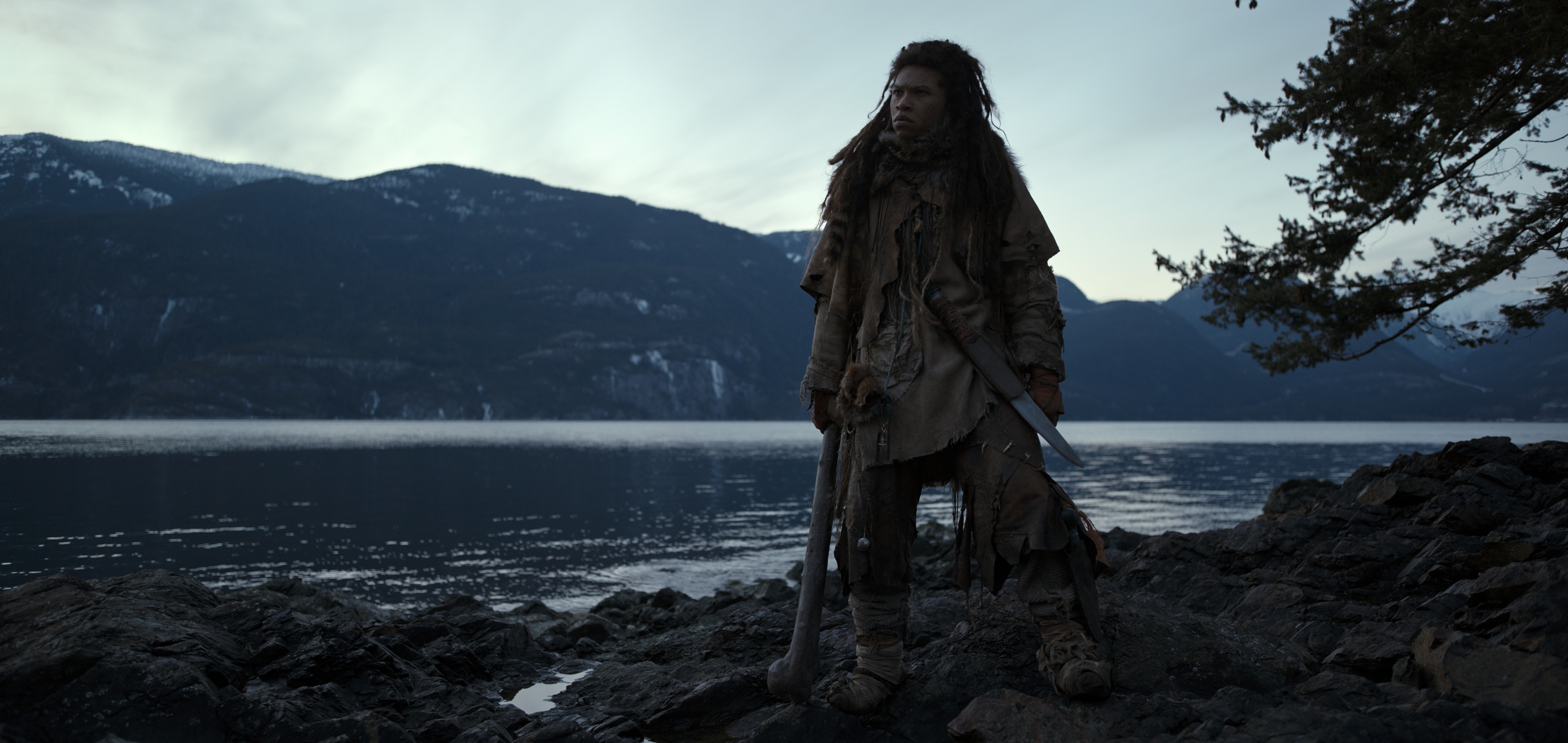 Franz Drameh as a rugged warrior by a mountain lake HD Wallpaper