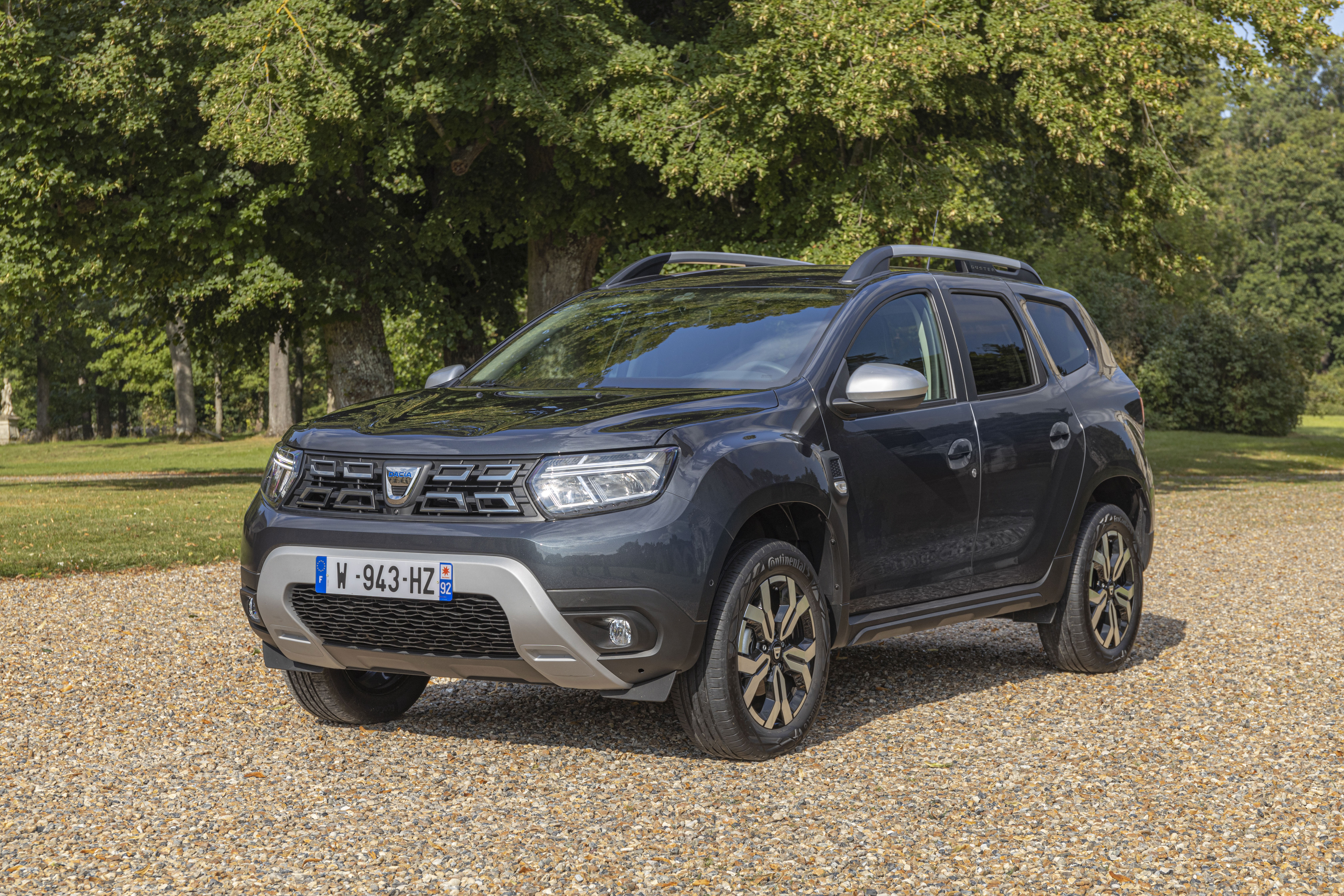 Dark Dacia Duster SUV parked on gravel path HD Wallpaper