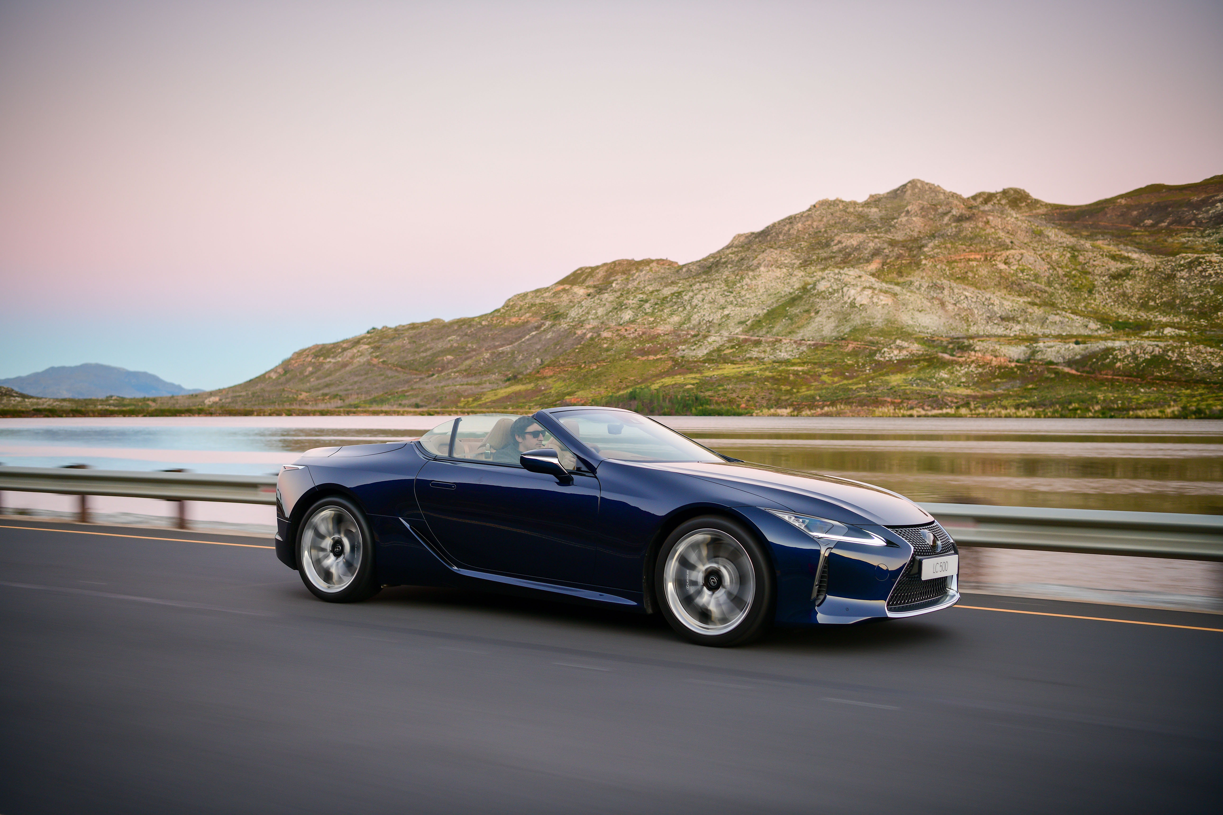 Blue Lexus LC 500 Cabriolet driving on a scenic road HD Wallpaper