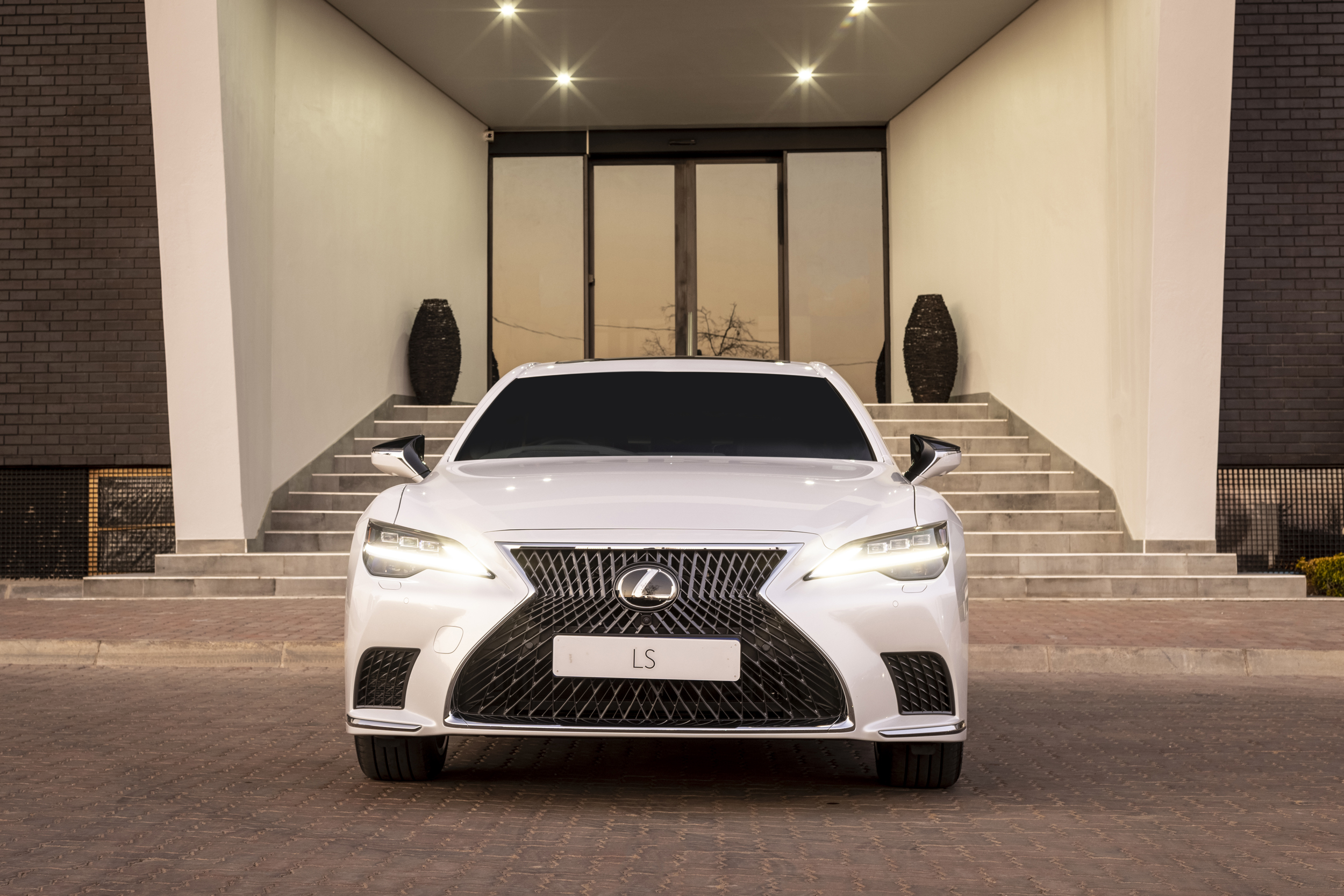 Lexus LS 500 luxury sedan parked at modern entrance HD Wallpaper