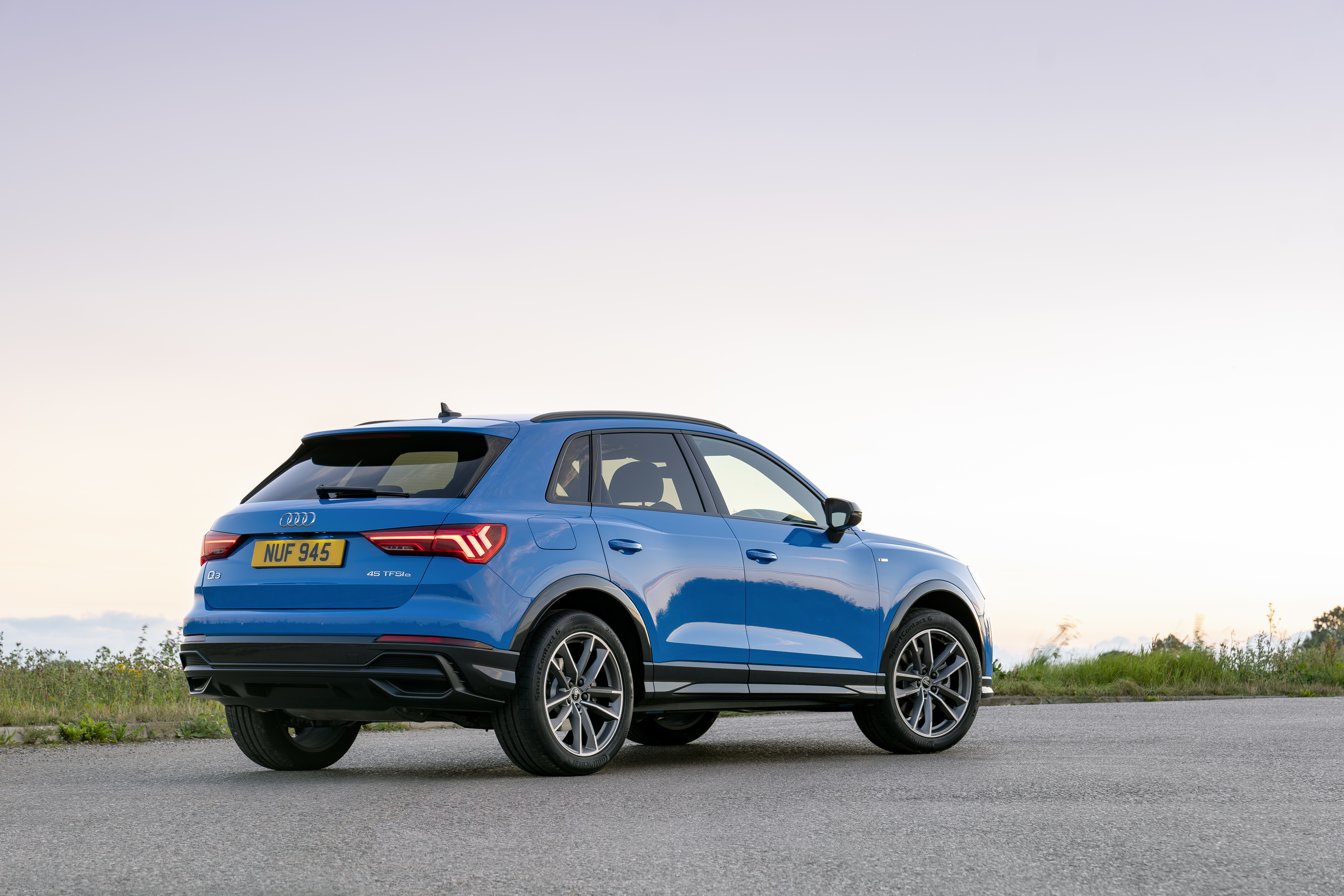 Blue Audi Q3 luxury SUV on an open road HD Wallpaper