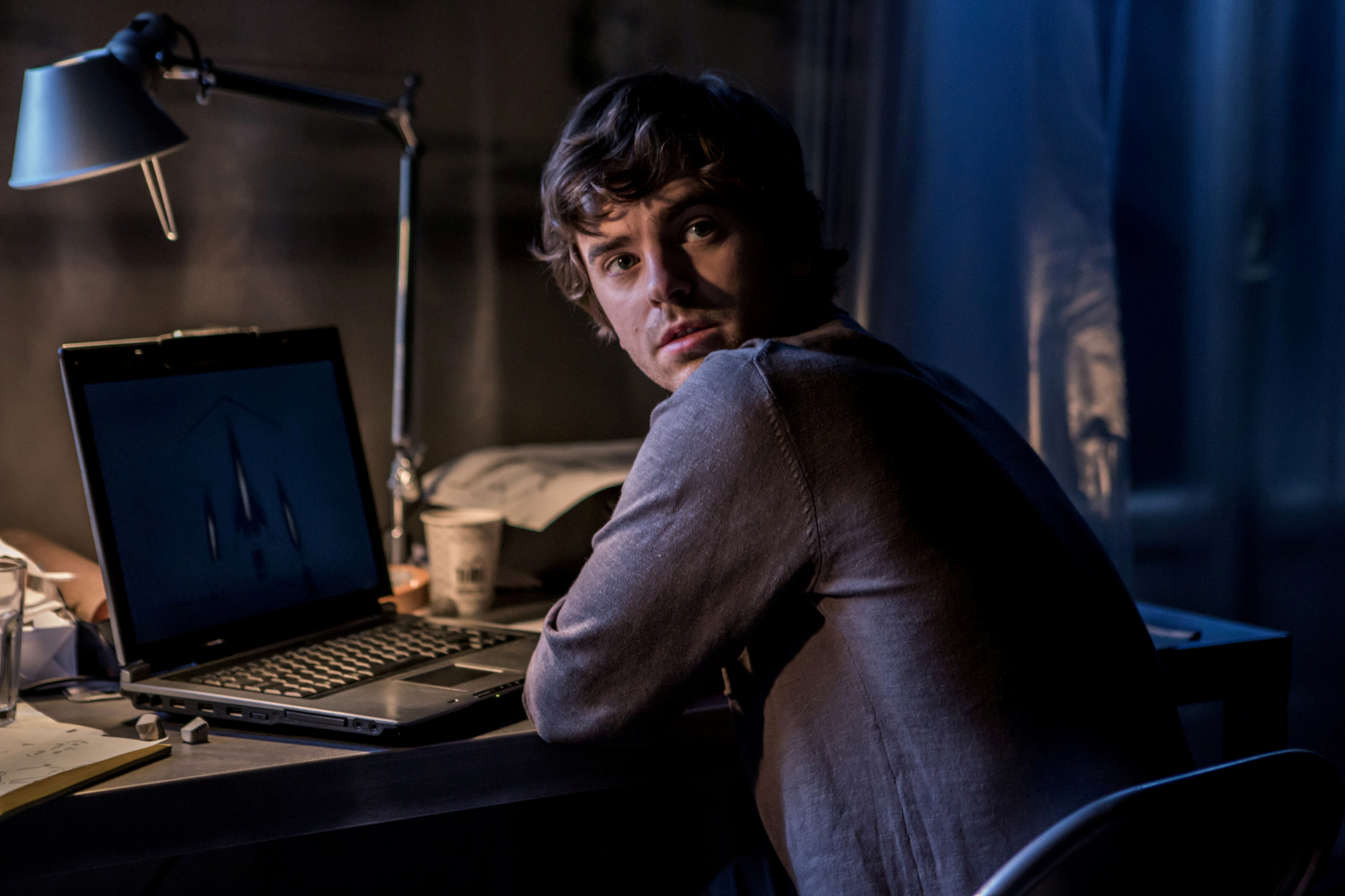 Freddie Highmore looks back from laptop in The Vault HD Wallpaper