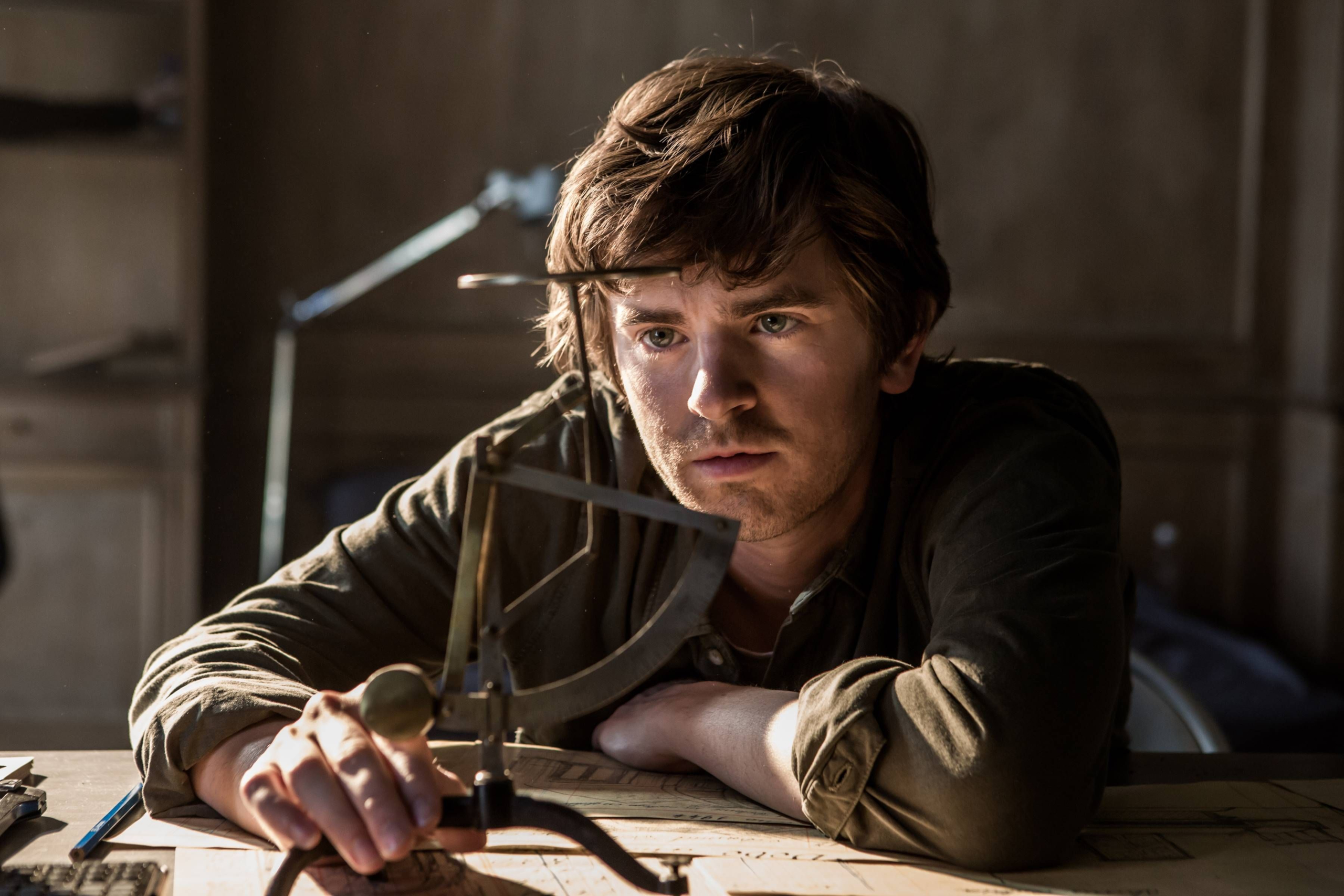 Freddie Highmore intently examining an instrument in The Vault HD Wallpaper