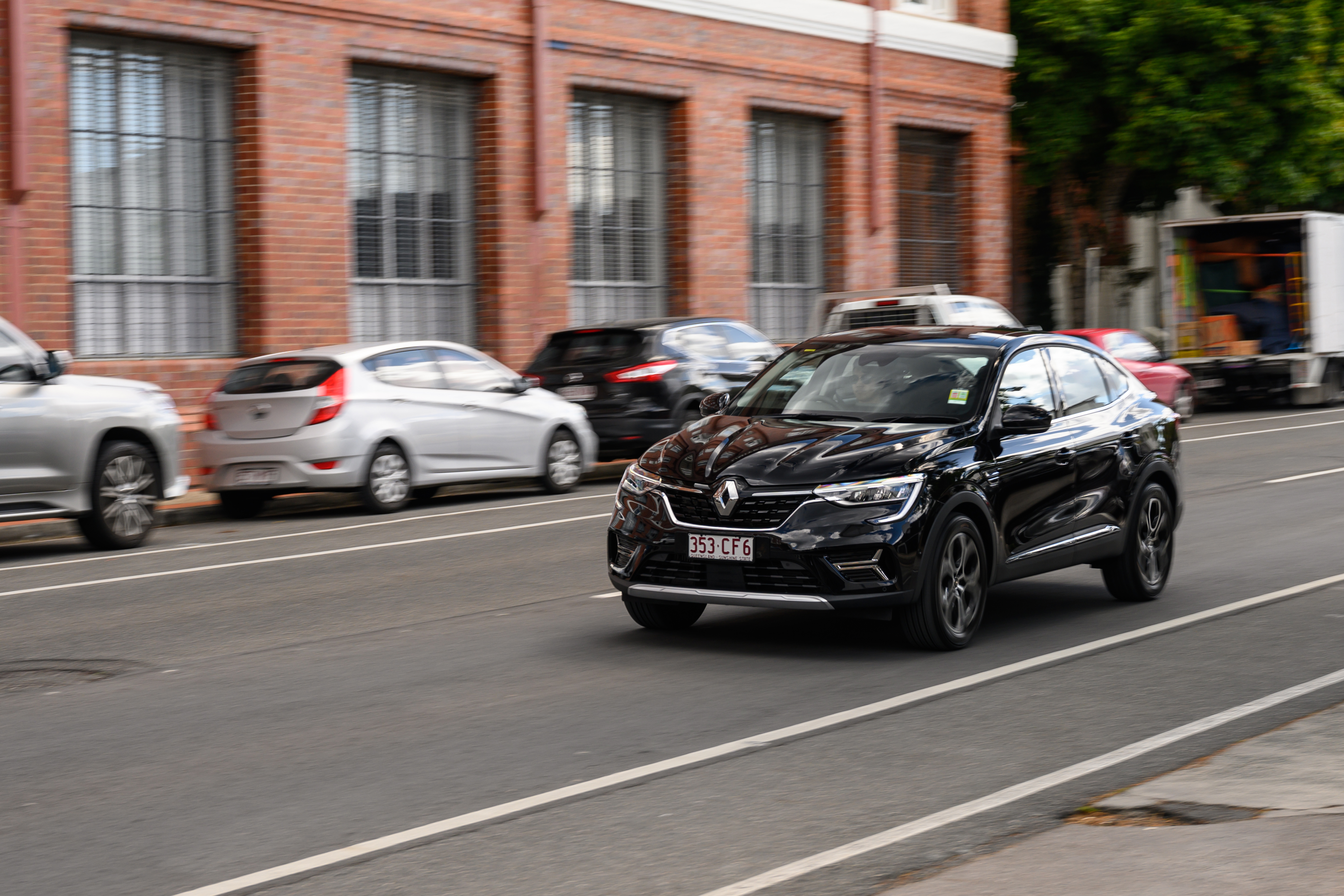 Black Renault Arkana SUV driving on city street HD Wallpaper