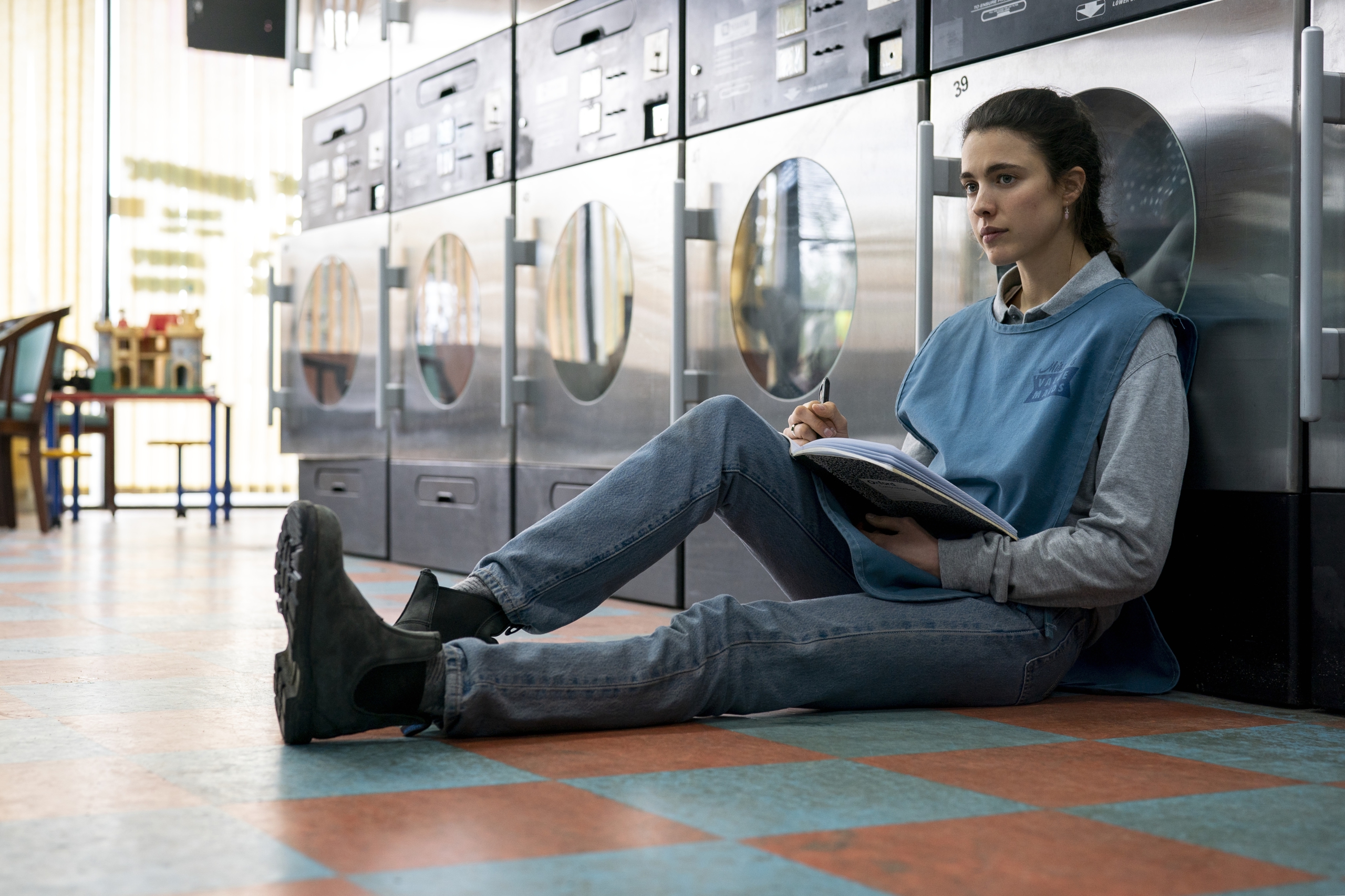 Maid: Margaret Qualley sitting in laundromat HD Wallpaper
