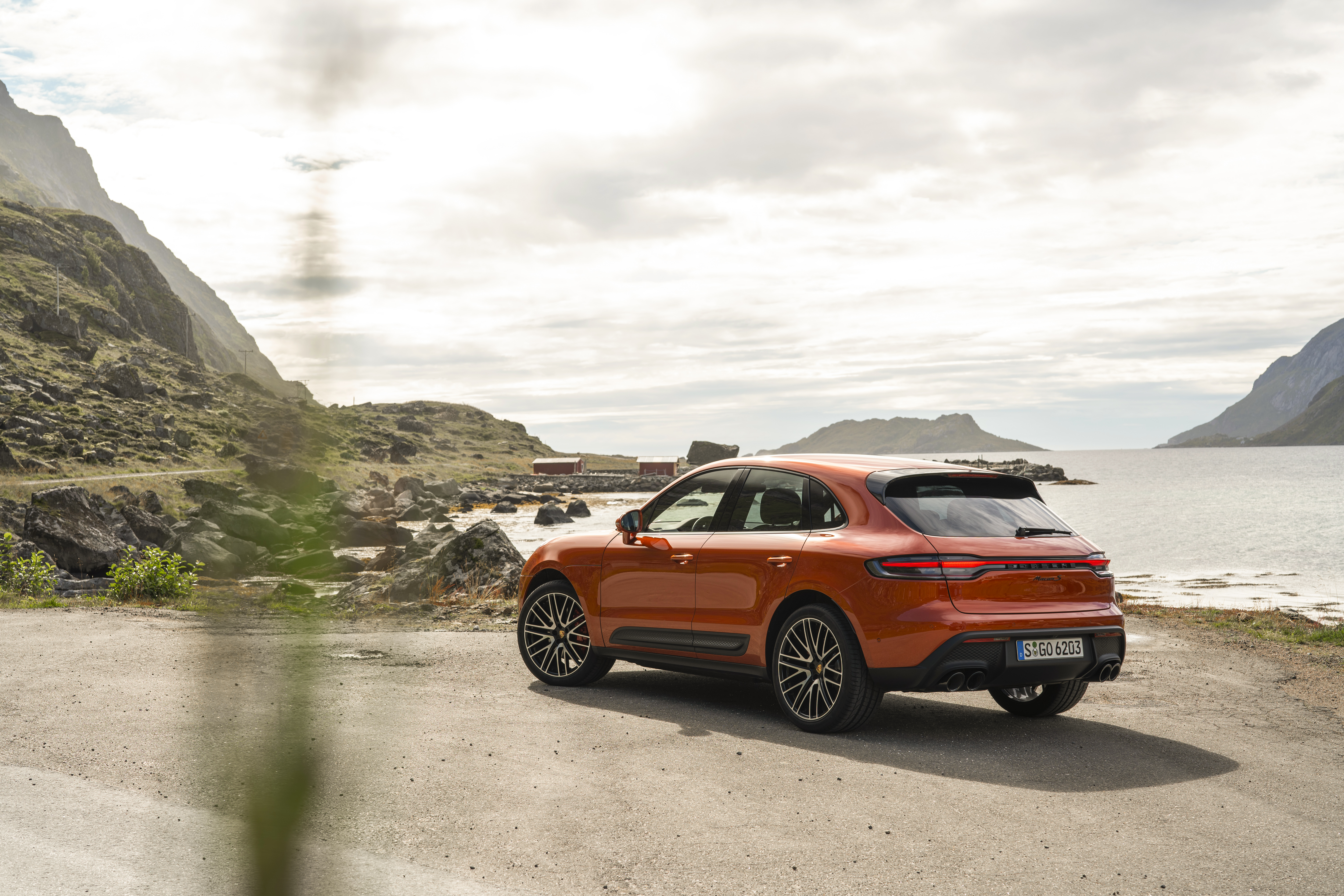 Orange Porsche Macan S SUV on a scenic coastal road HD Wallpaper