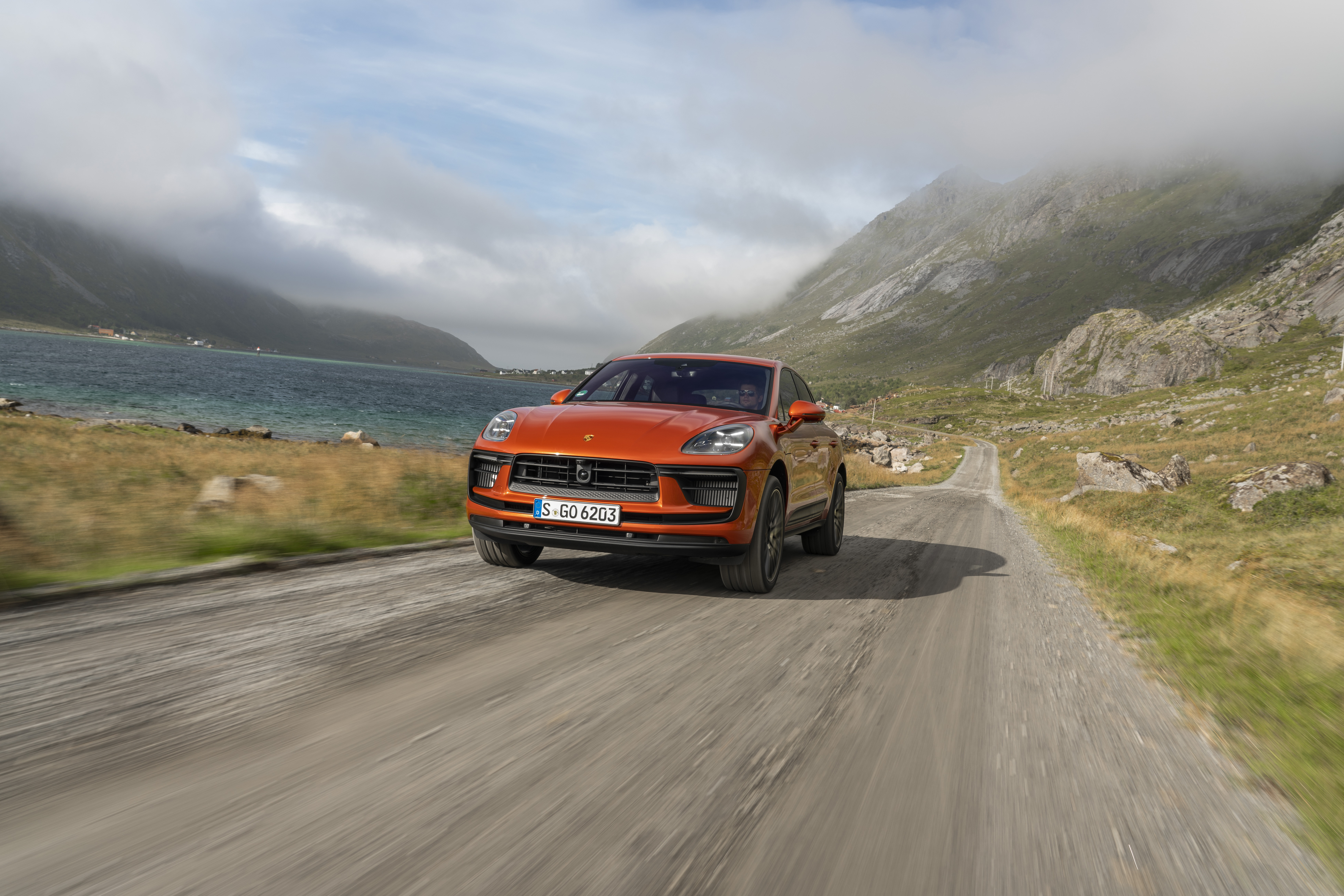 Orange Porsche Macan S SUV on a scenic road HD Wallpaper
