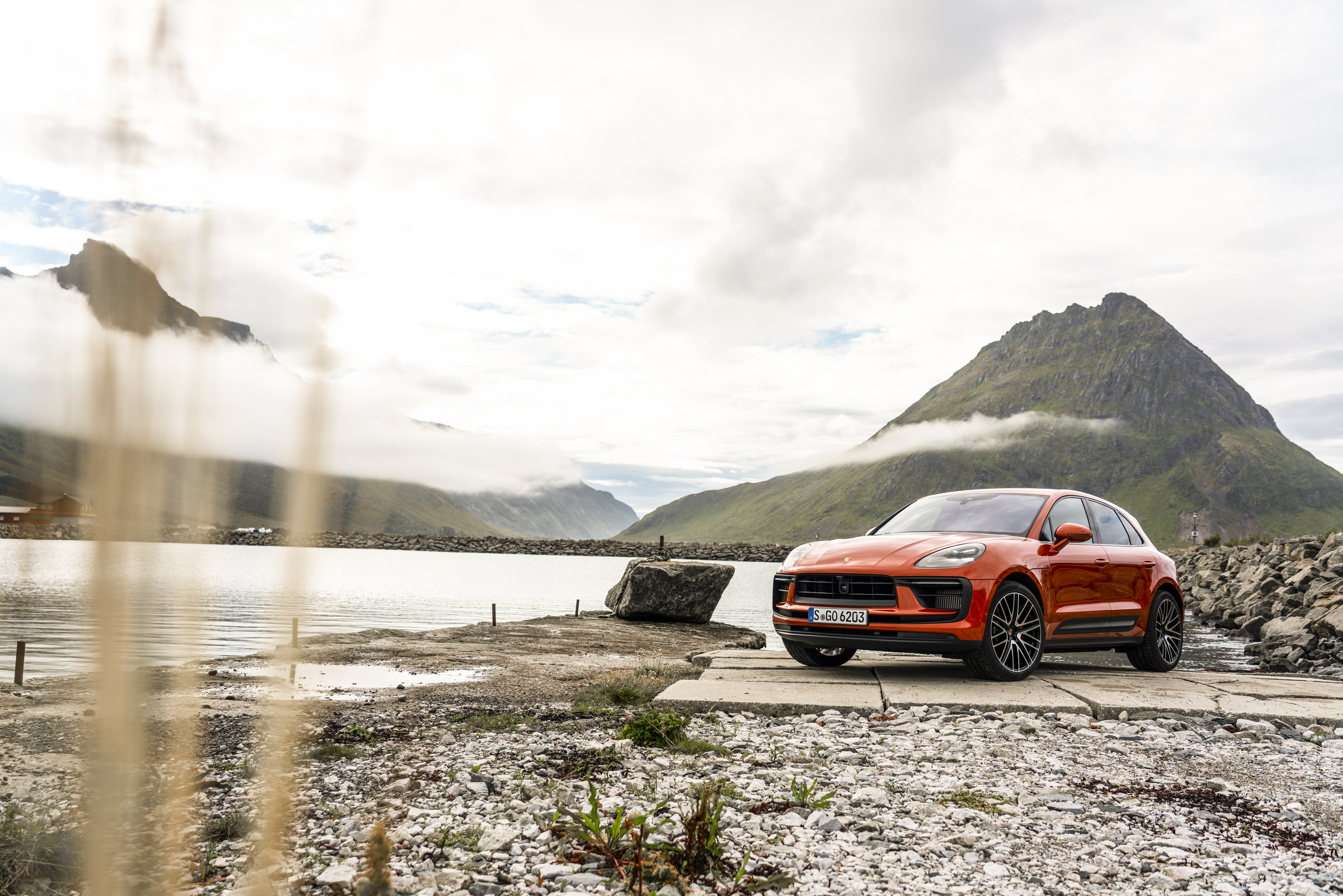 Orange Porsche Macan S SUV in a scenic mountain landscape HD Wallpaper