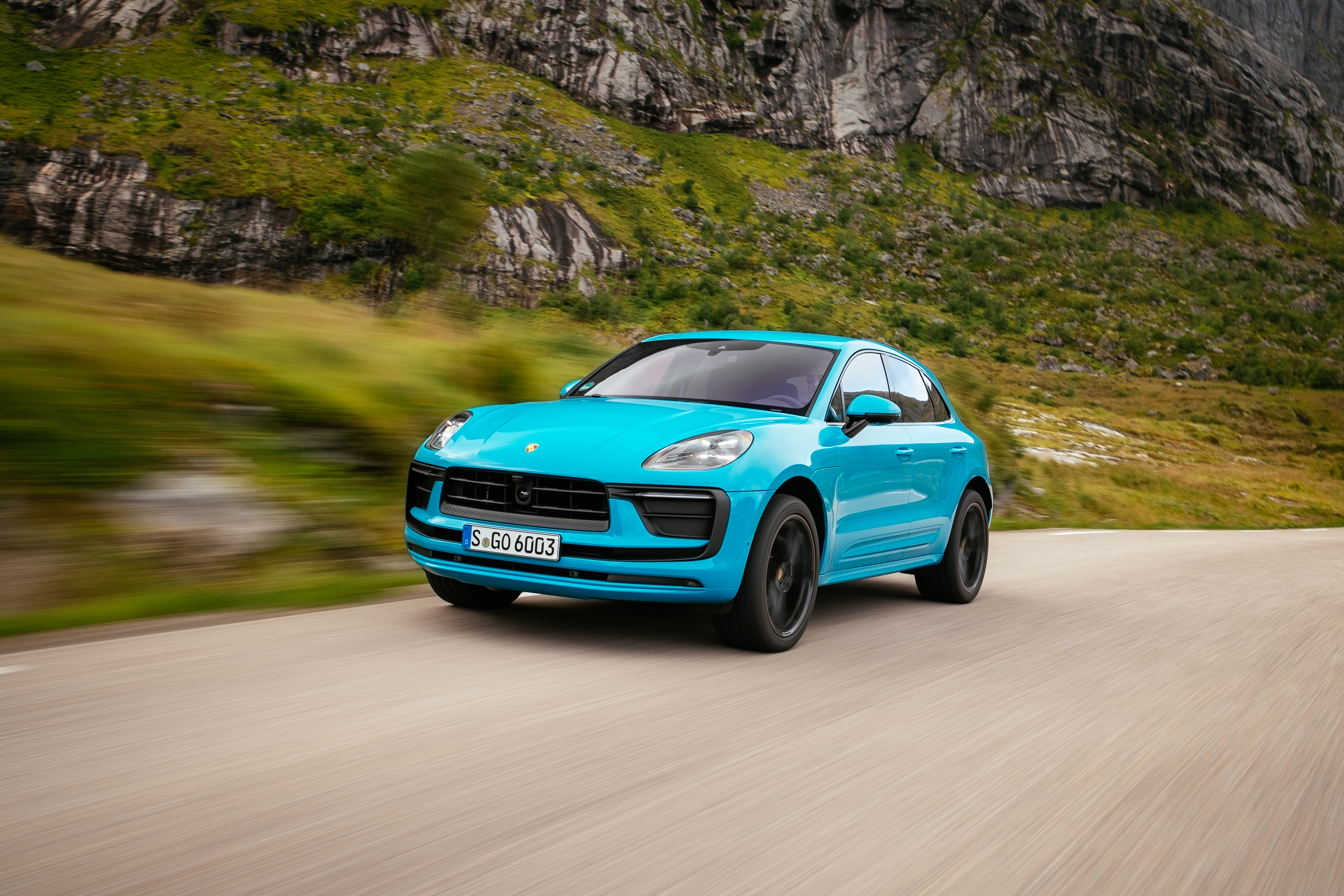 Blue Porsche Macan SUV driving on a scenic road HD Wallpaper