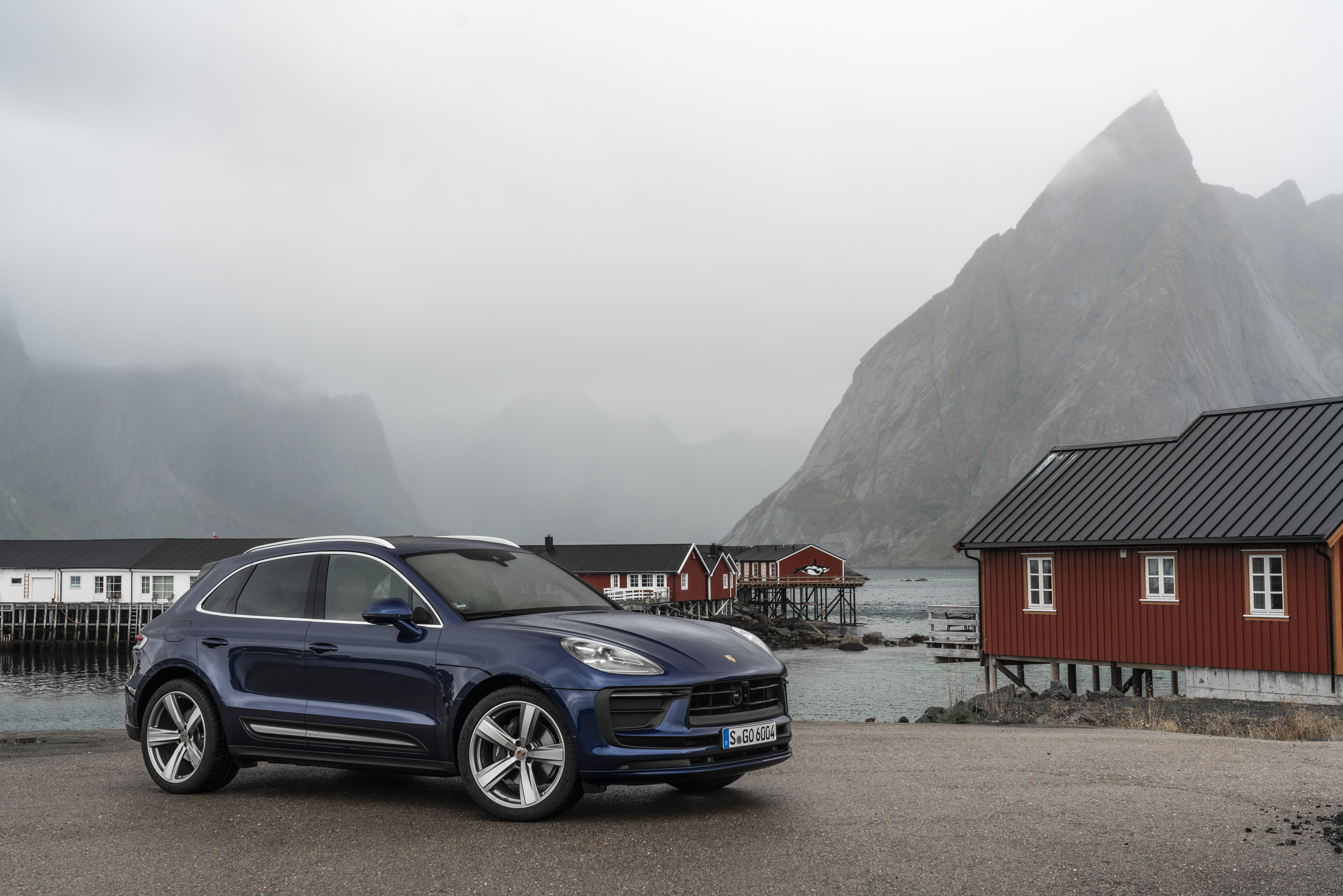 Luxury Blue Porsche Macan SUV in a misty village HD Wallpaper