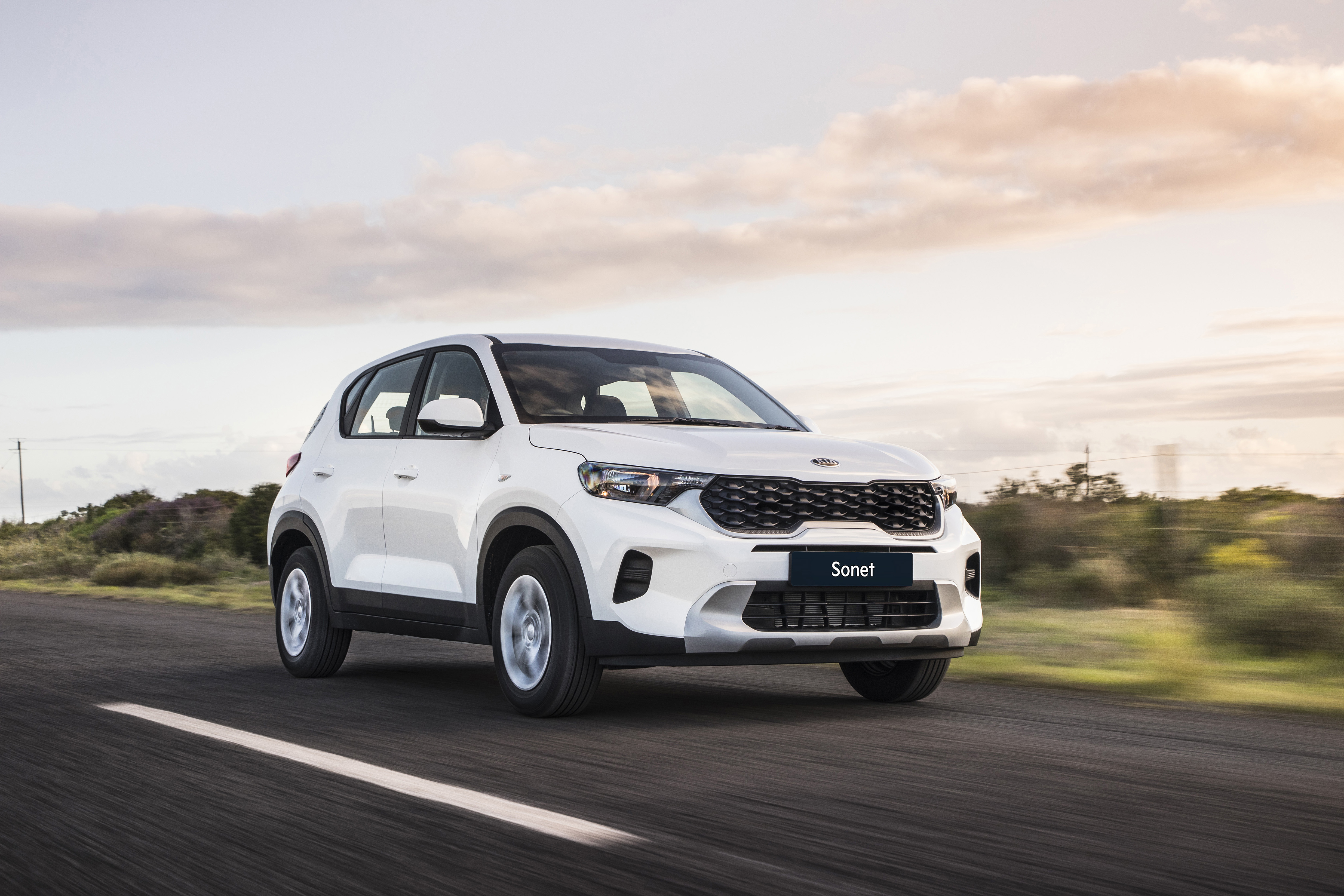 Kia Sonet LX SUV driving on road HD Wallpaper