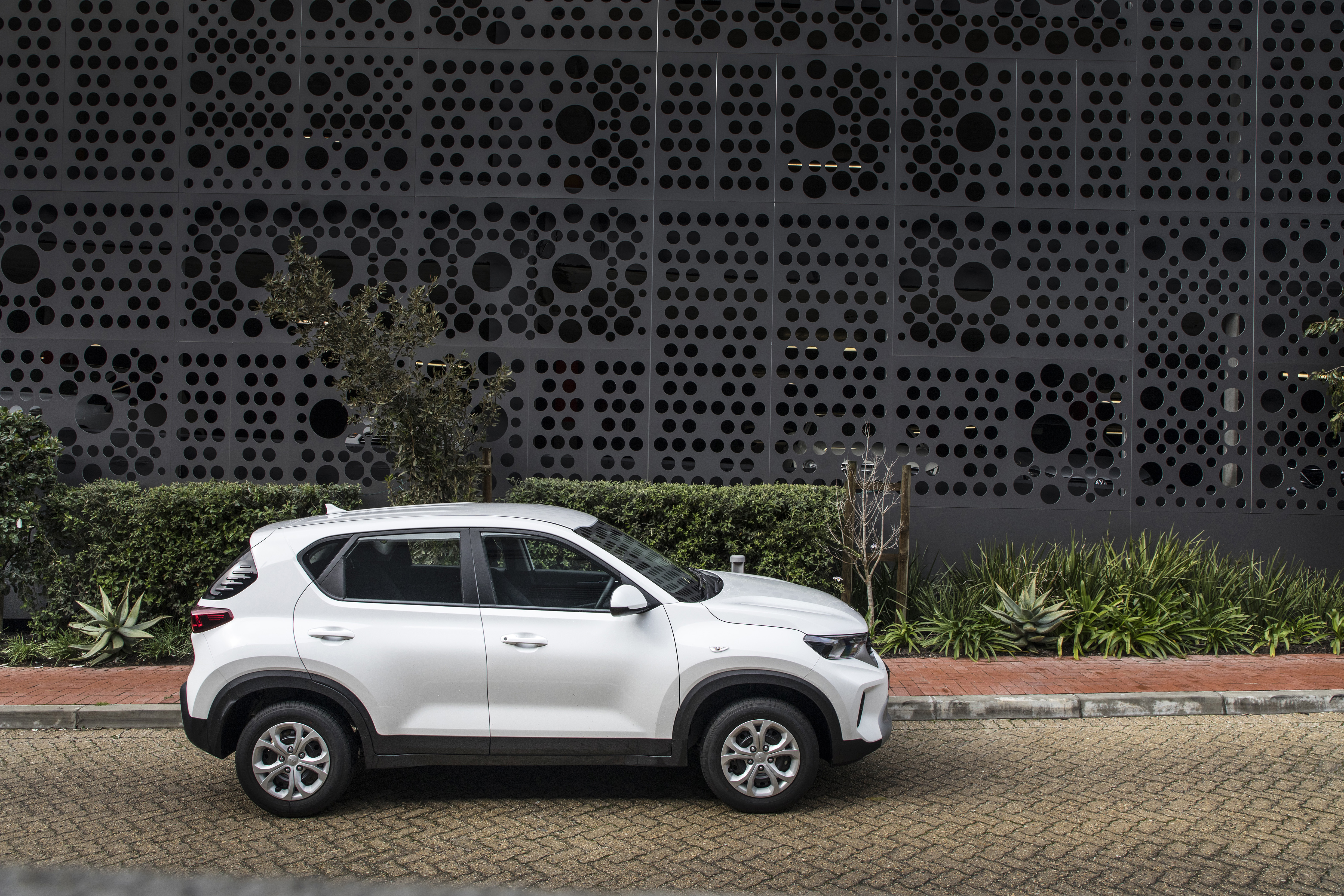 White Kia Sonet LX SUV by modern building HD Wallpaper