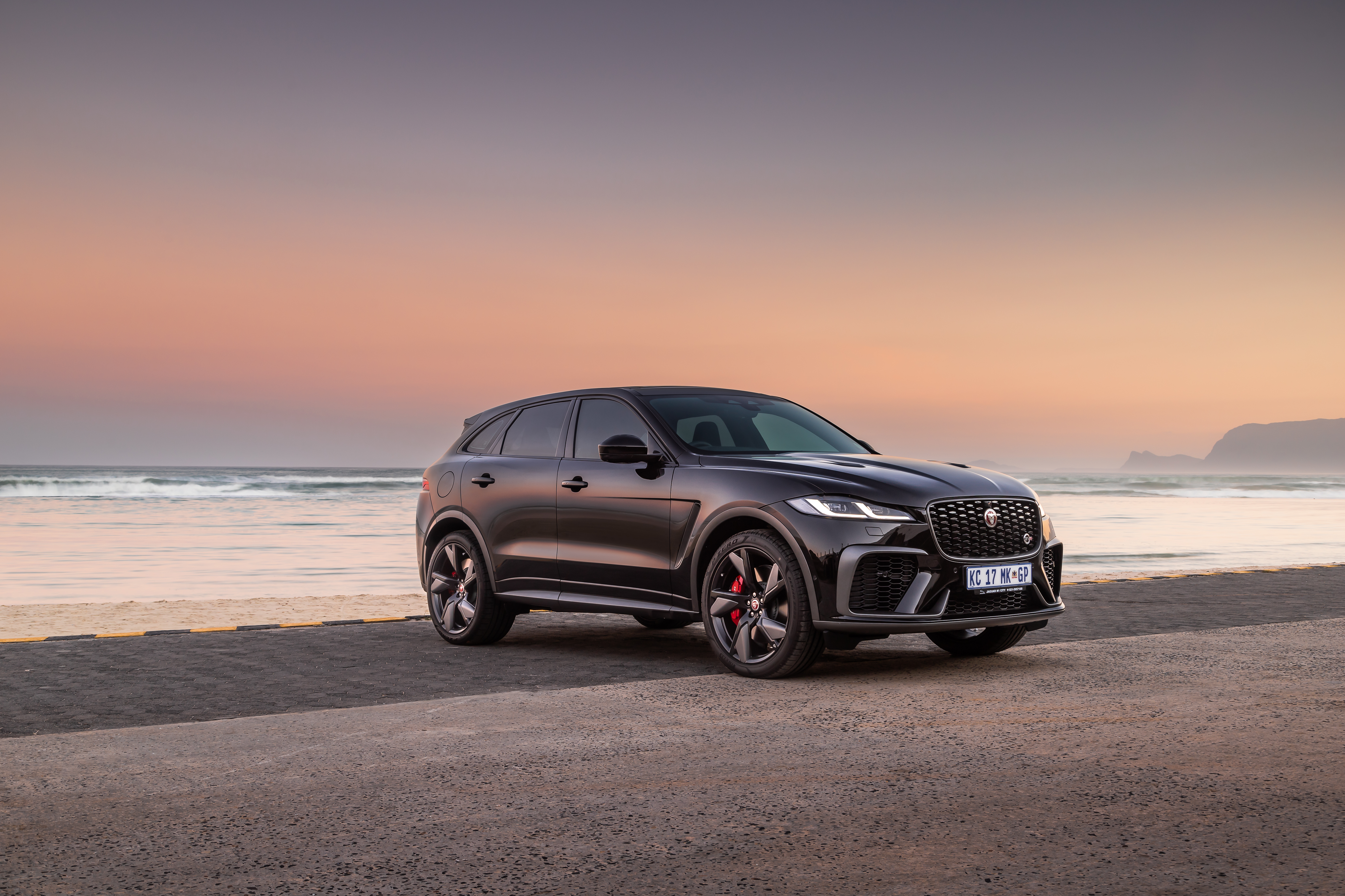 2021 Black Jaguar F-Pace SVR SUV by the ocean at sunset HD Wallpaper
