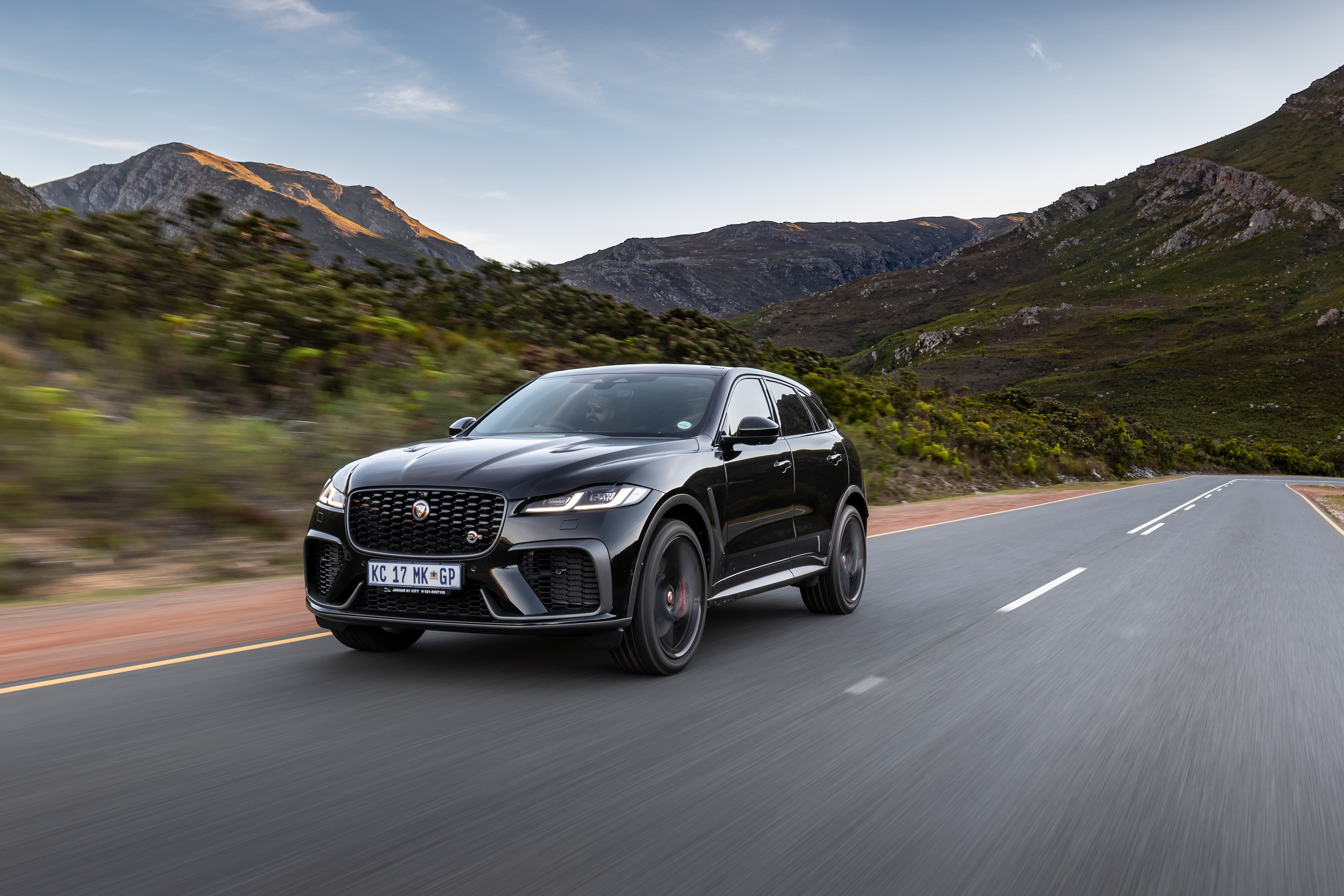 Black Jaguar F-Pace SVR SUV driving on mountain road HD Wallpaper