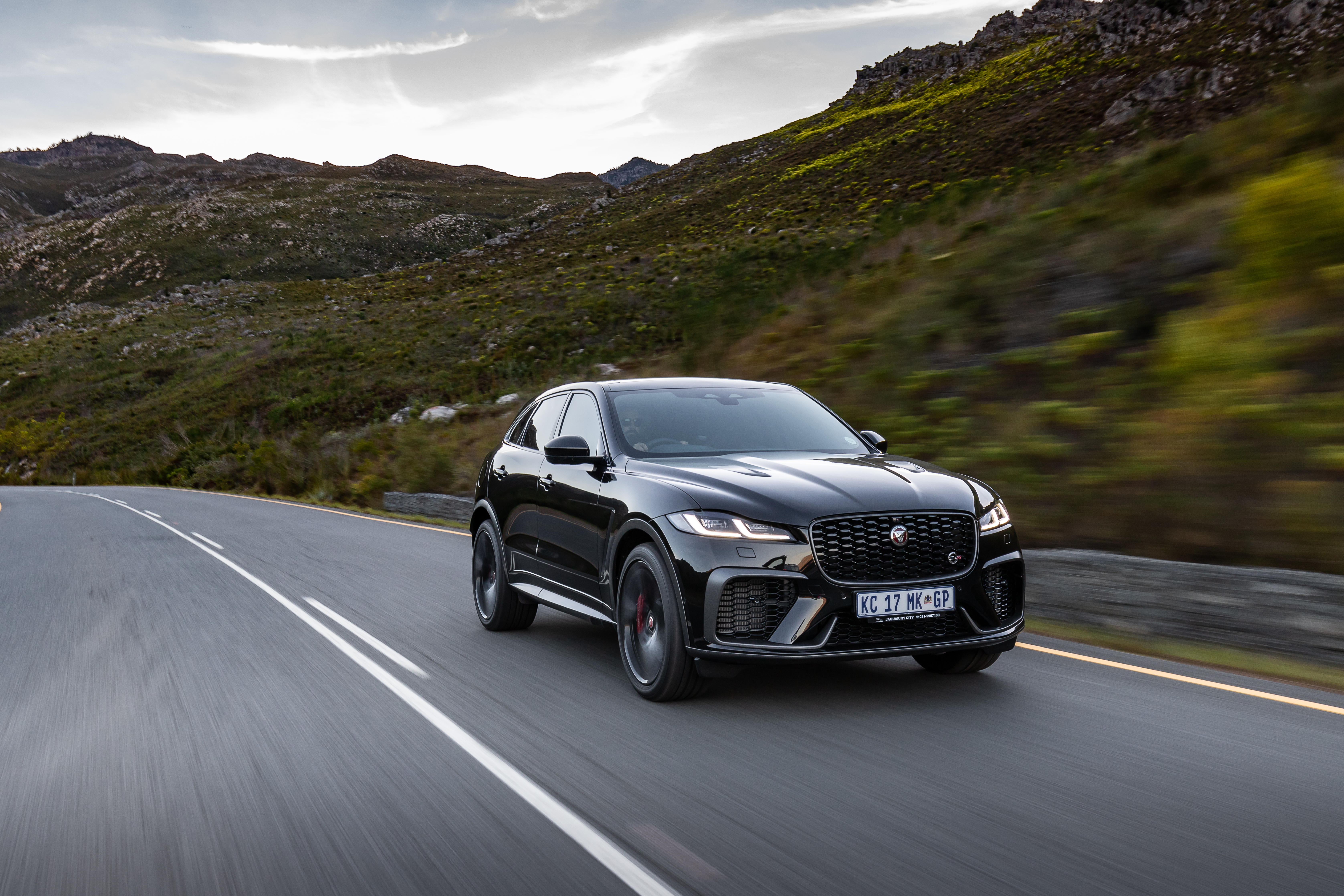 Black 2021 Jaguar F-Pace SVR SUV on mountain road HD Wallpaper