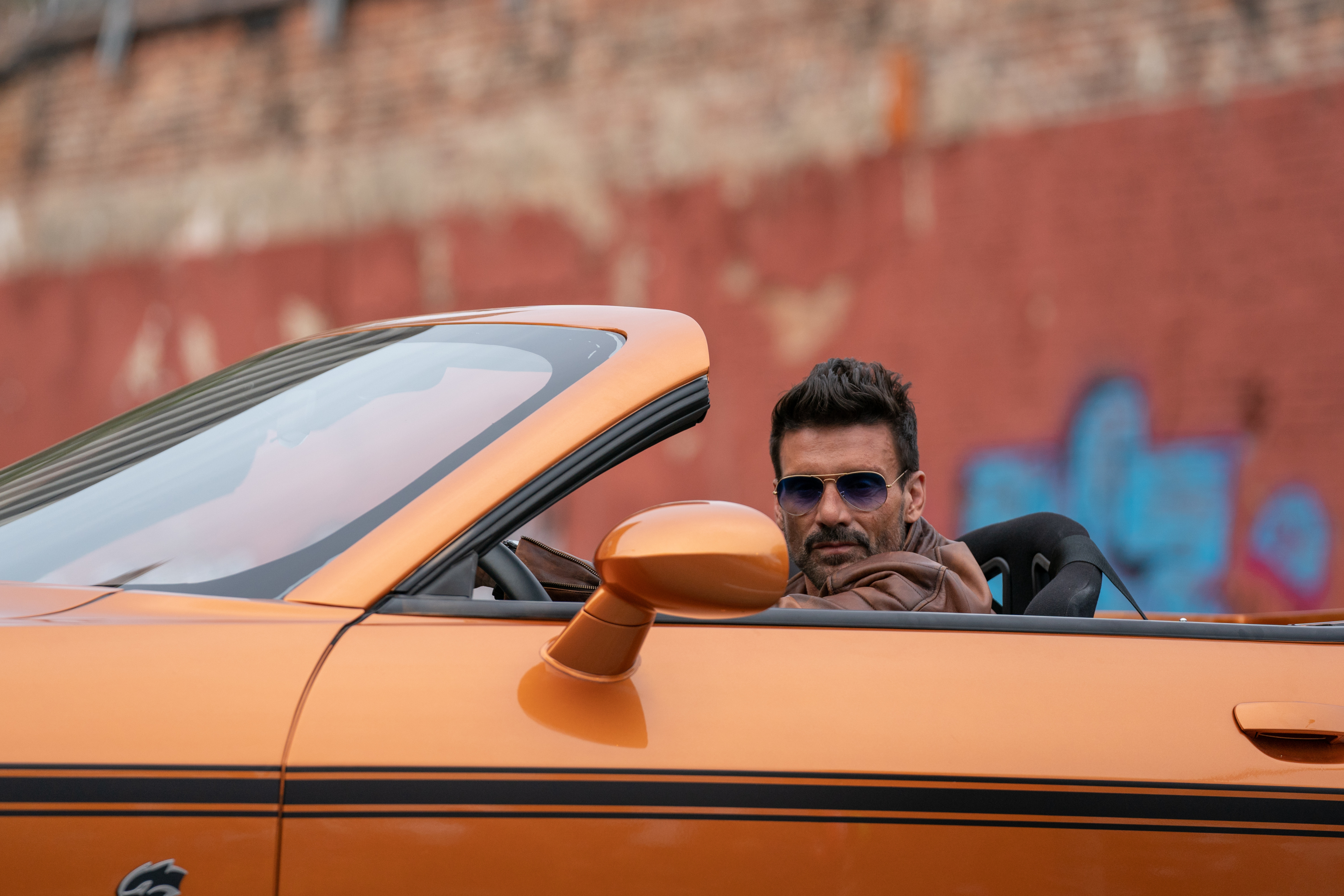 Frank Grillo in an orange convertible from Boss Level HD Wallpaper