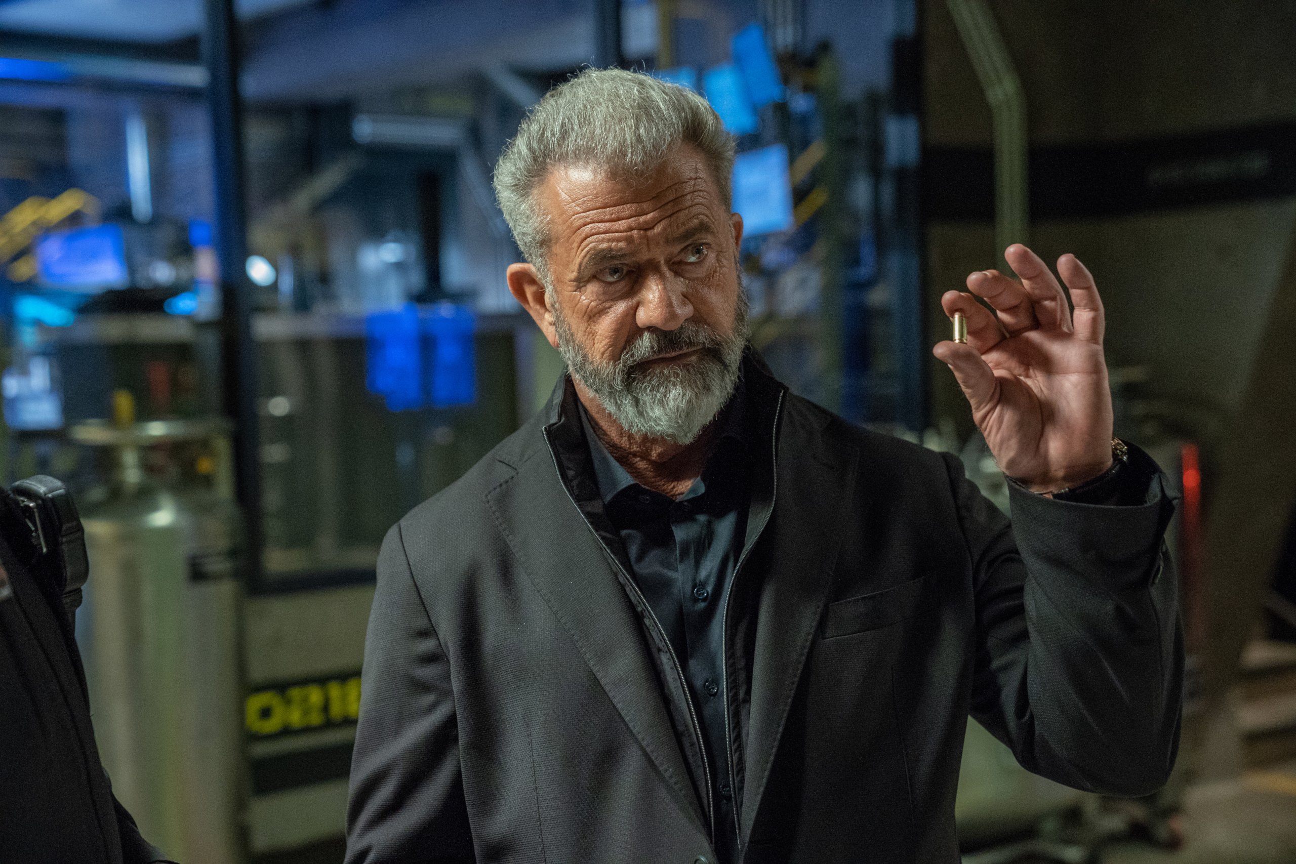 Mel Gibson holding a bullet in Boss Level HD Wallpaper
