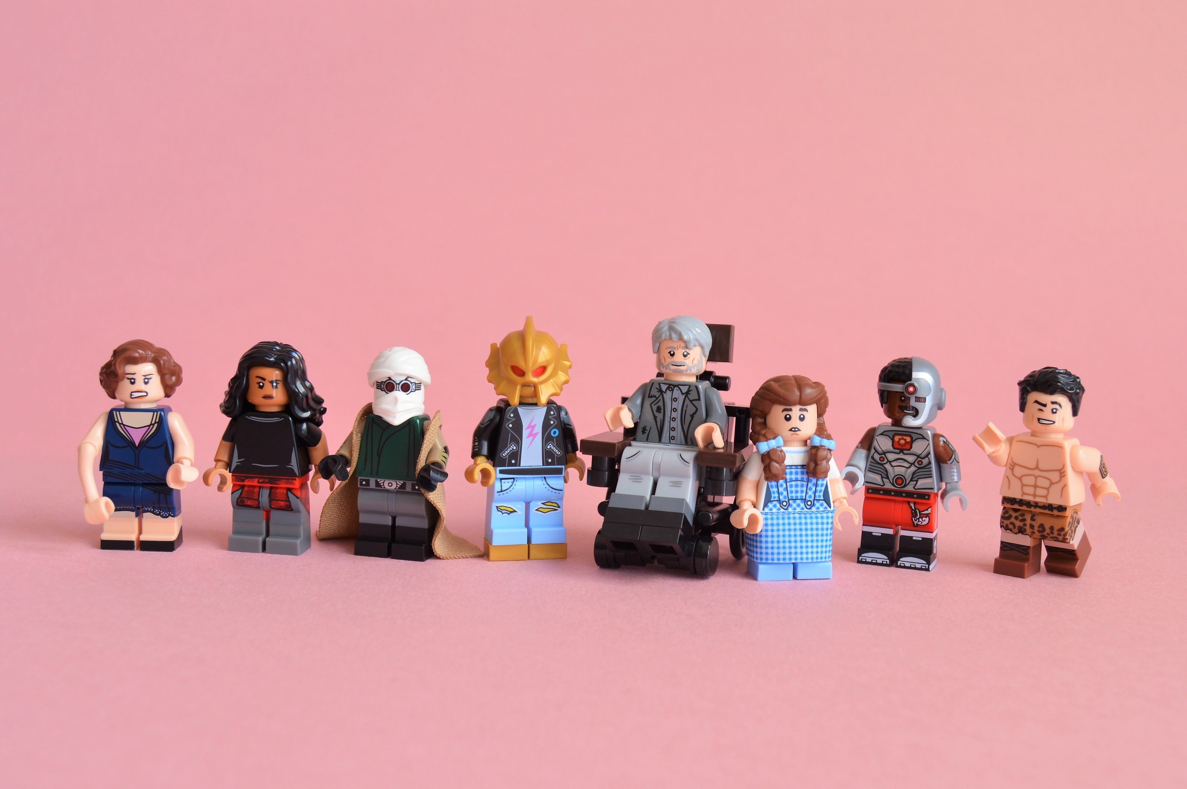 Lego Doom Patrol characters and Dorothy on pink background HD Wallpaper