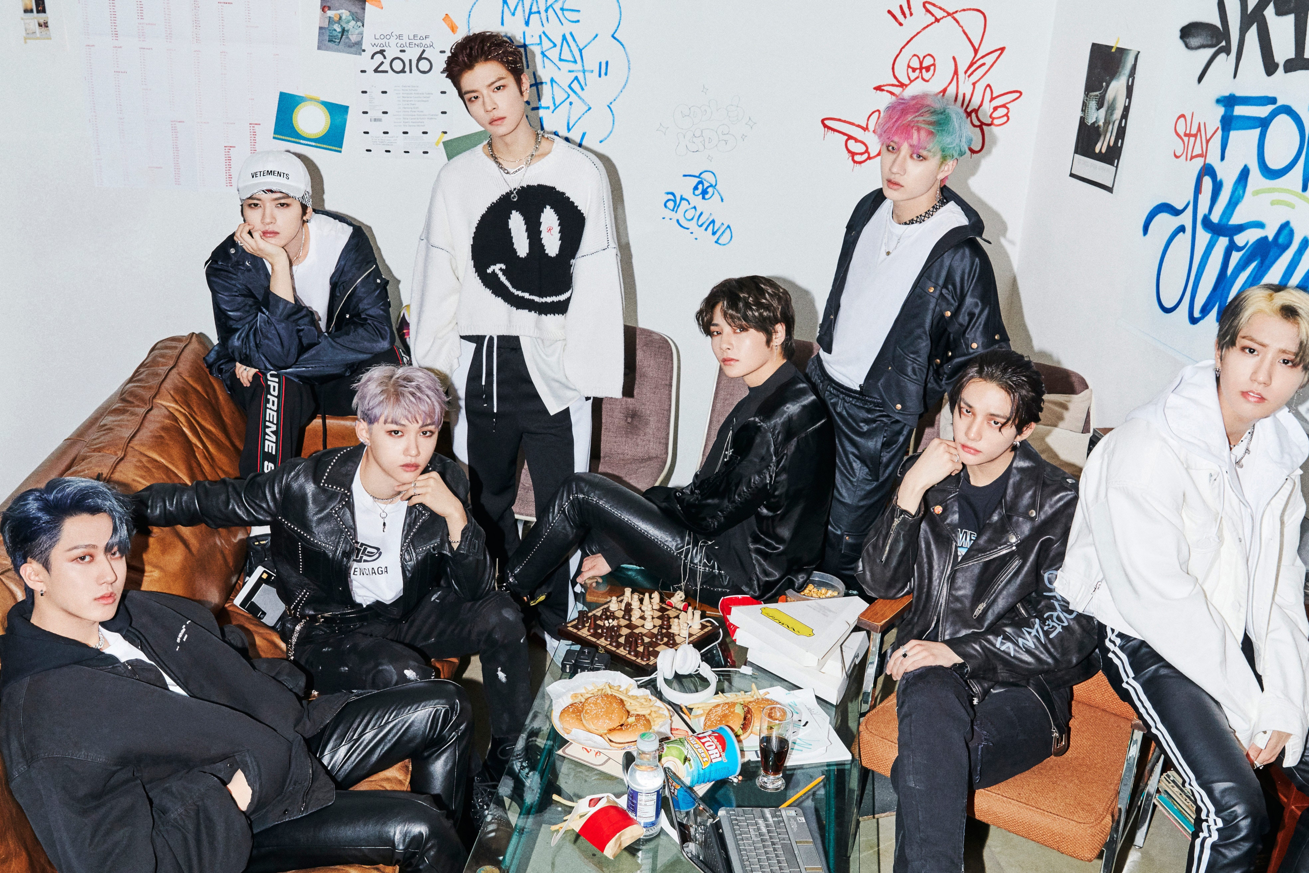 Stray Kids K-Pop group in a casual, graffiti-filled room HD Wallpaper