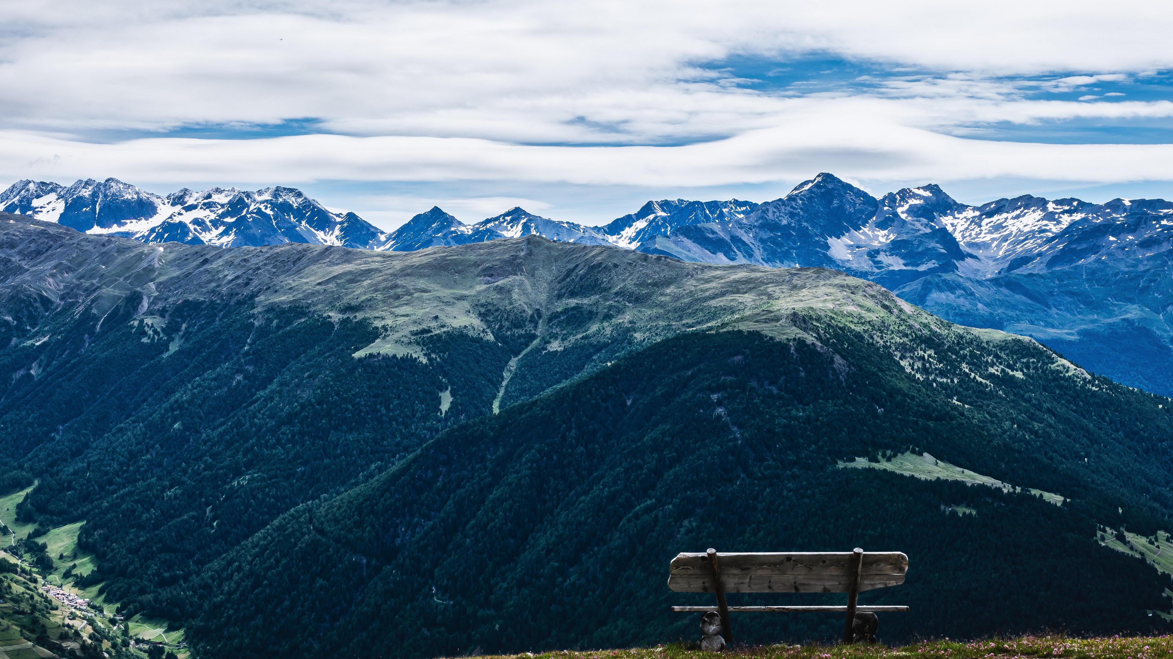 Bench overlooking a vast mountain panorama HD Wallpaper
