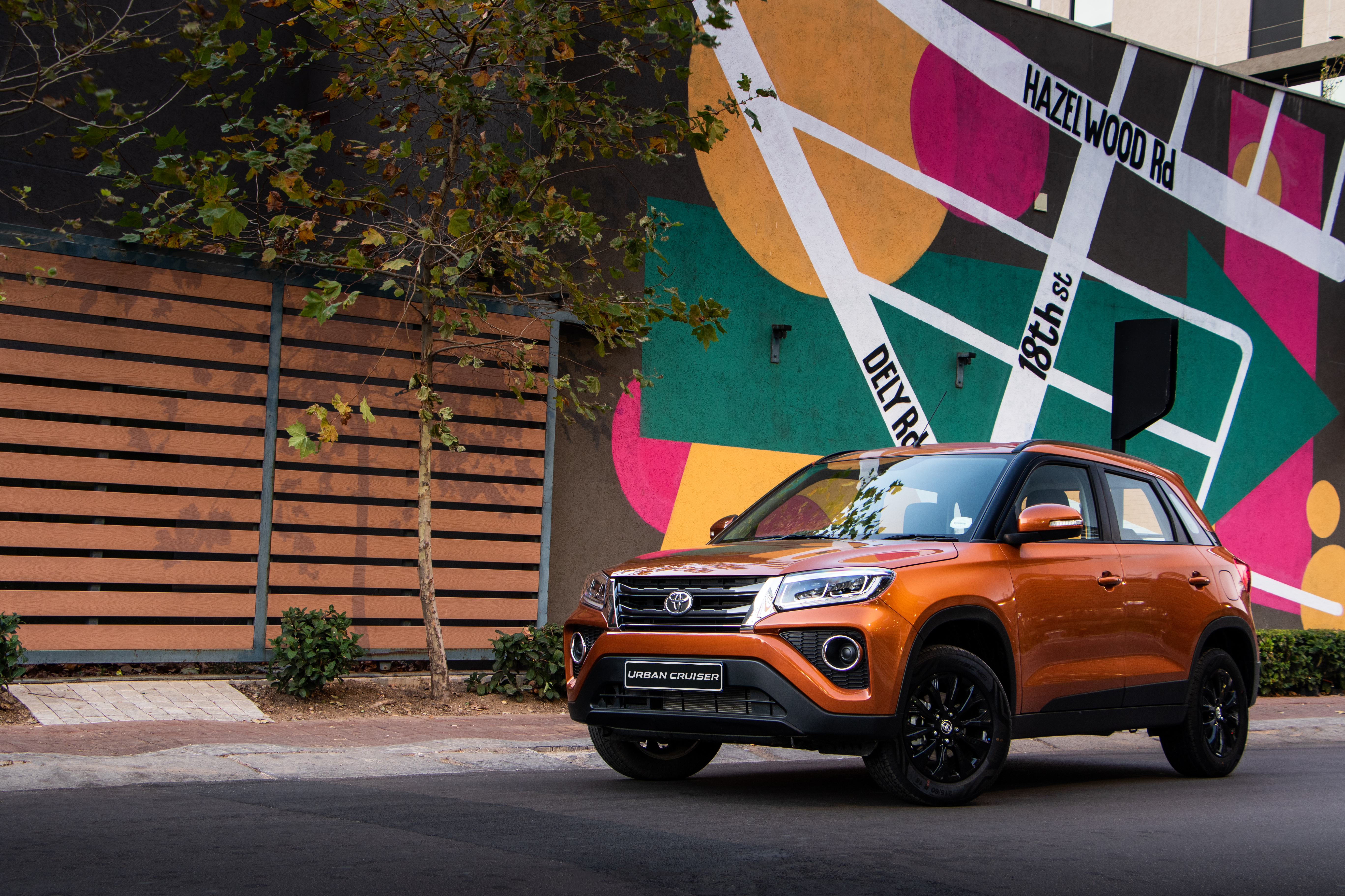 4K Orange Toyota Urban Cruiser SUV by colorful mural HD Wallpaper