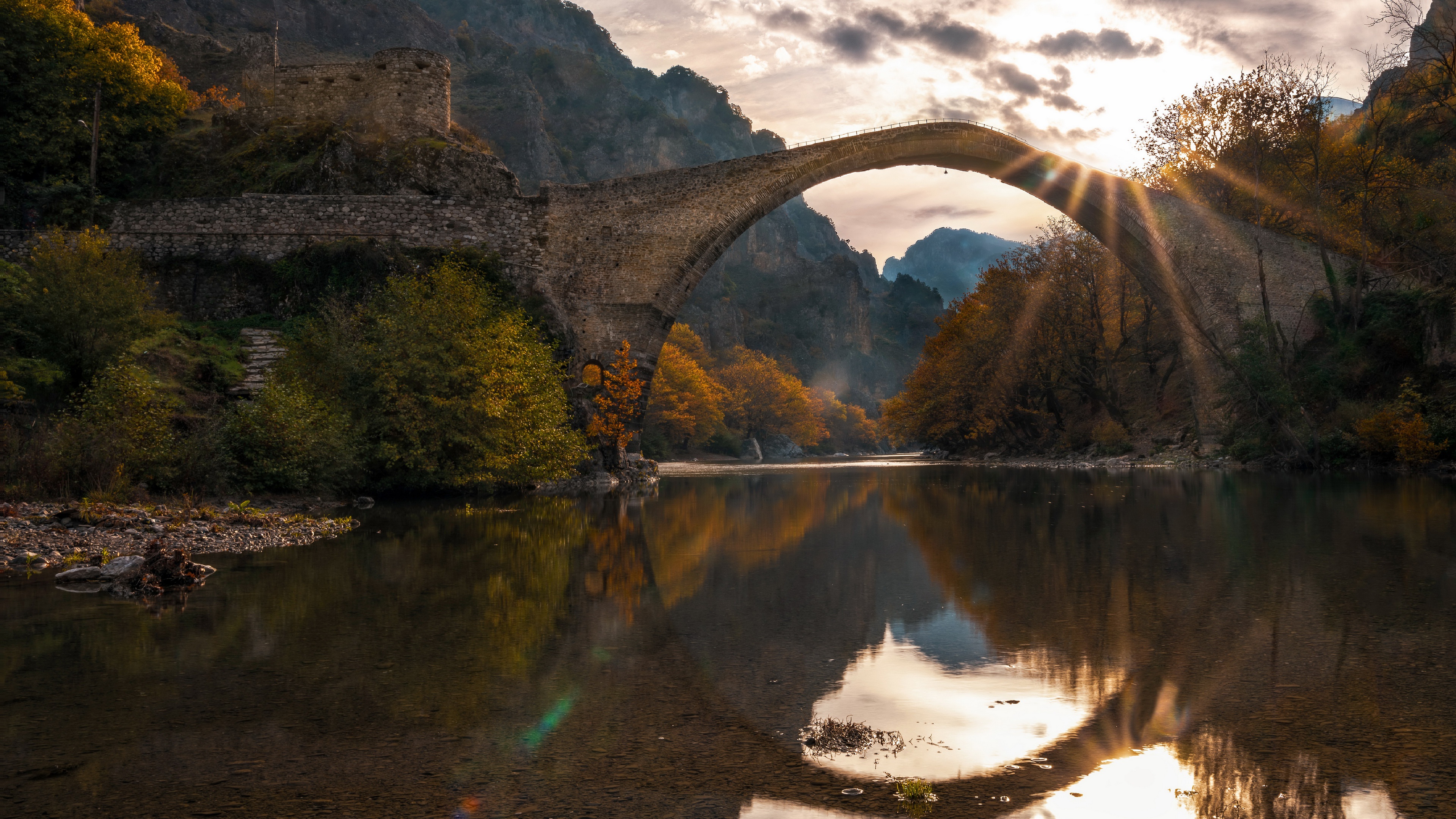 Ancient Stone Arch Bridge over River in Autumn Sunlight HD Wallpaper