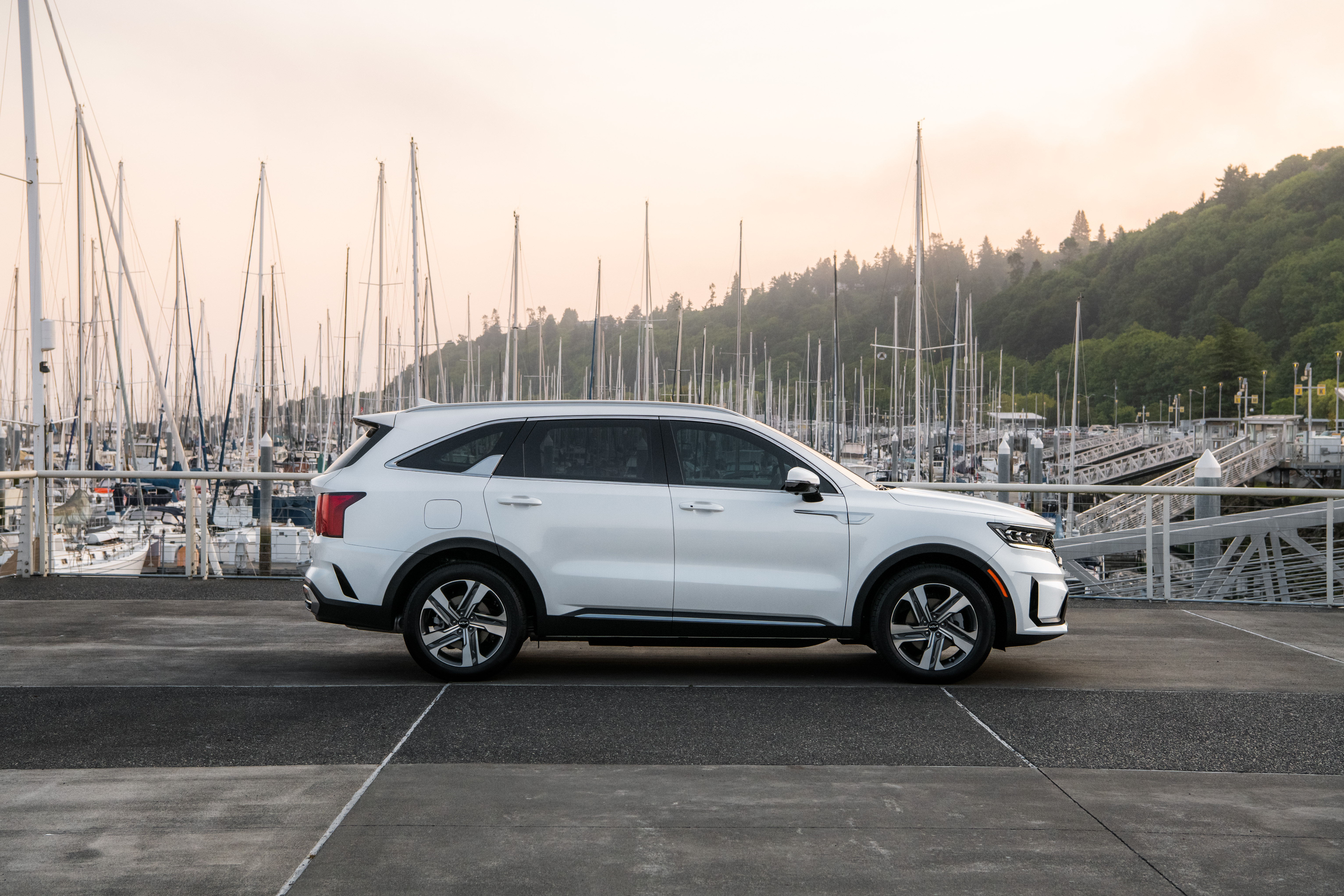 White Kia Sorento PHEV SUV at a marina with sailboats HD Wallpaper