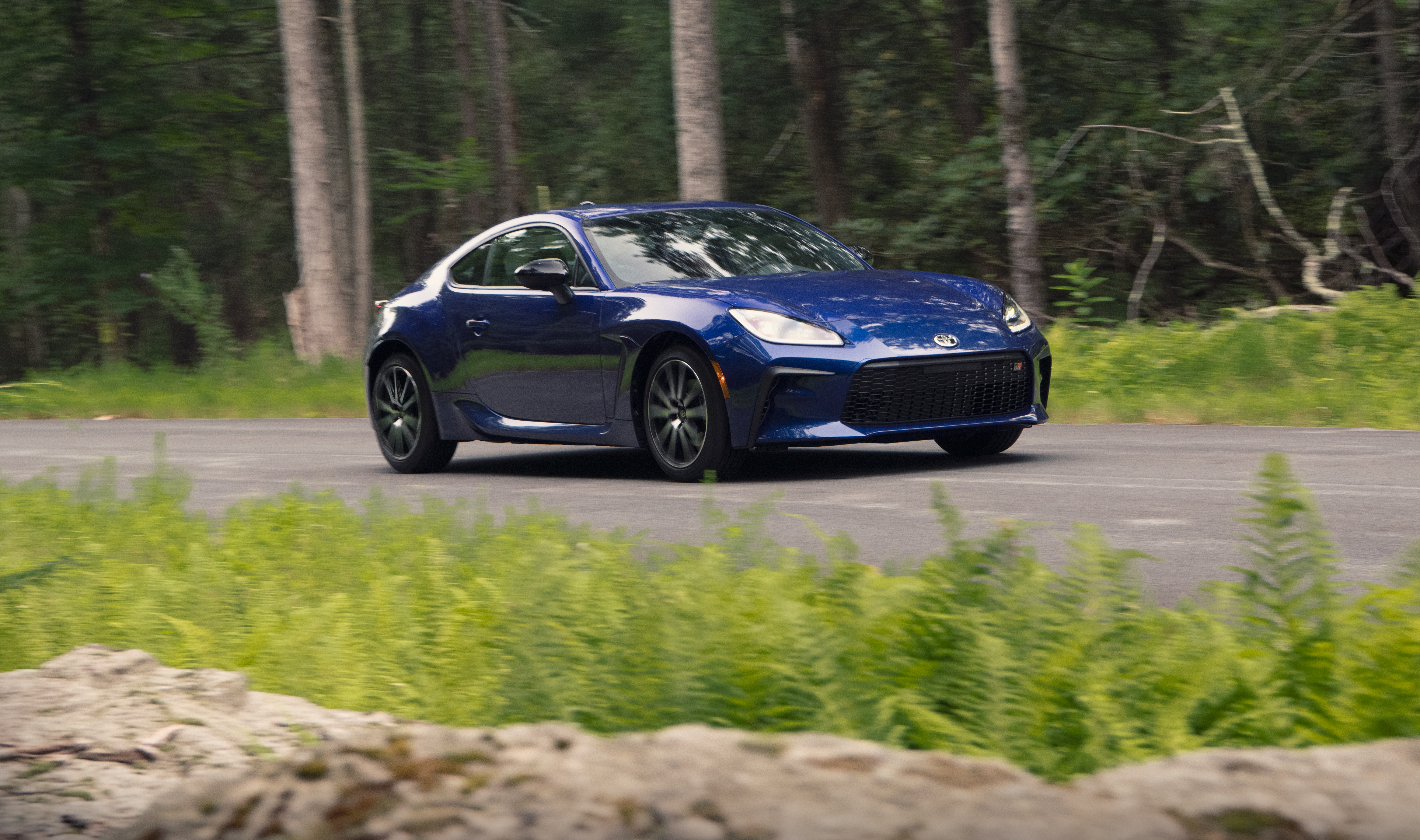 Blue Toyota GR 86 Sport Car on Forest Road HD Wallpaper