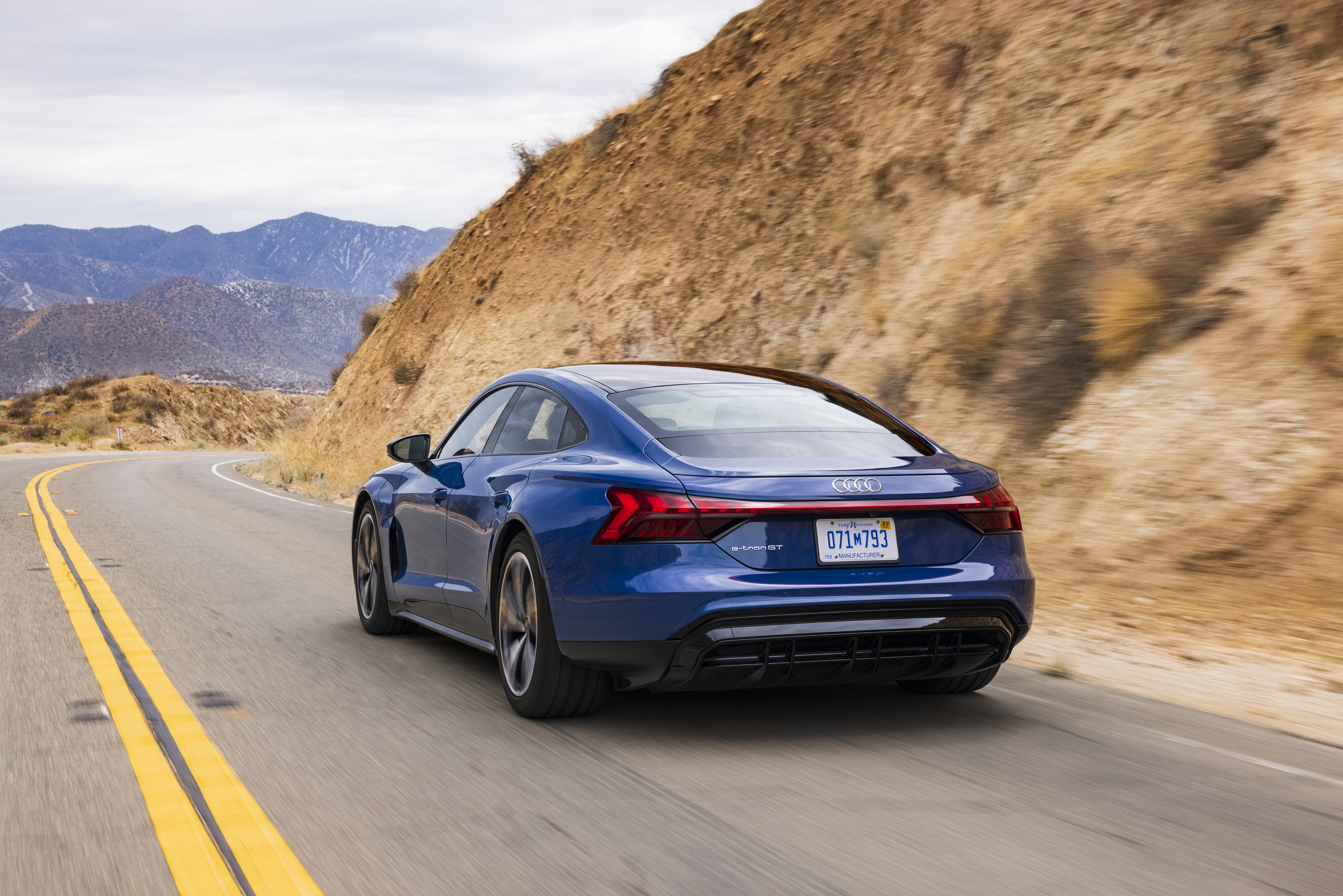 Blue Audi e-tron GT Quattro driving on a mountain road HD Wallpaper