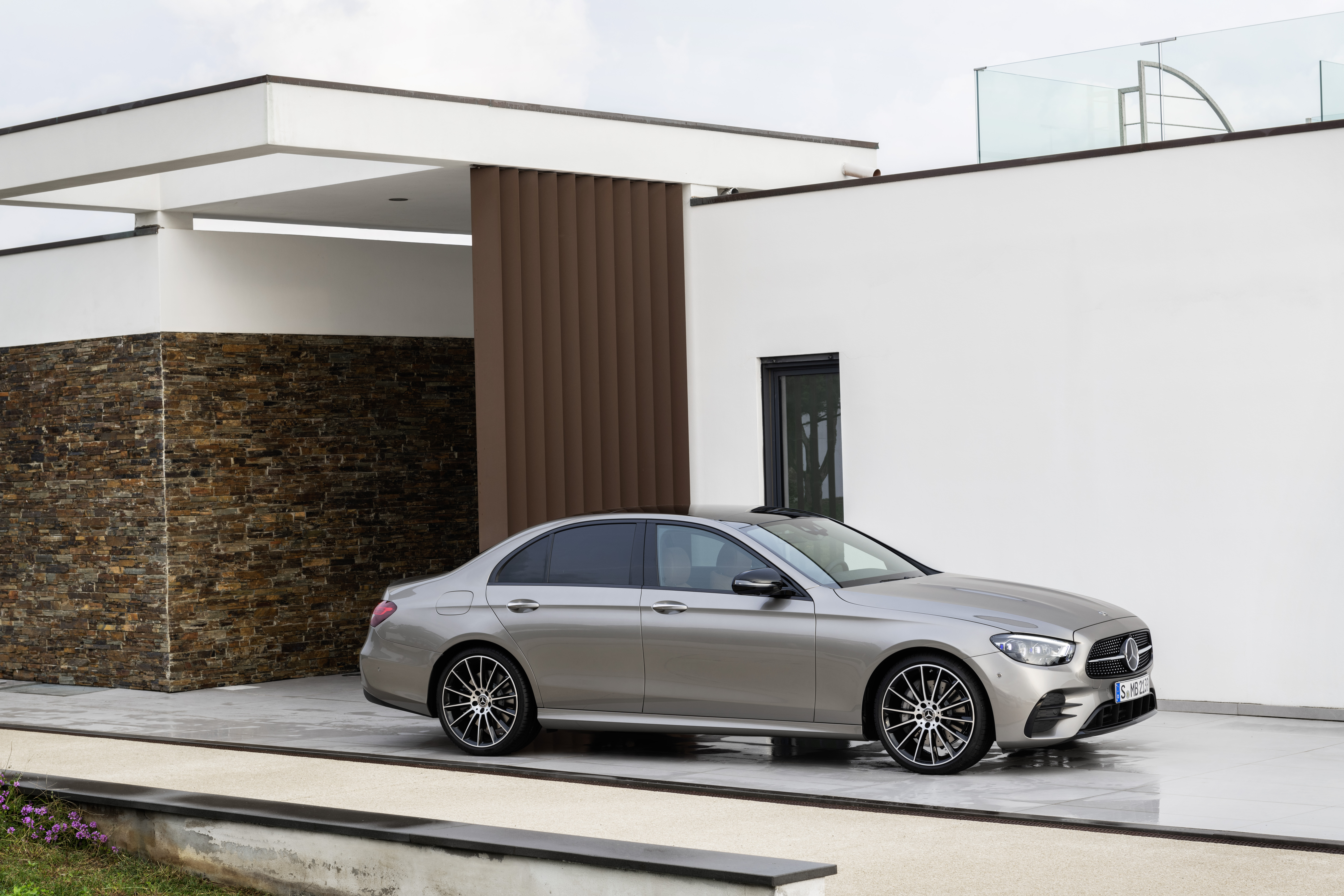 Silver Mercedes-Benz E 450 parked outside a modern home HD Wallpaper