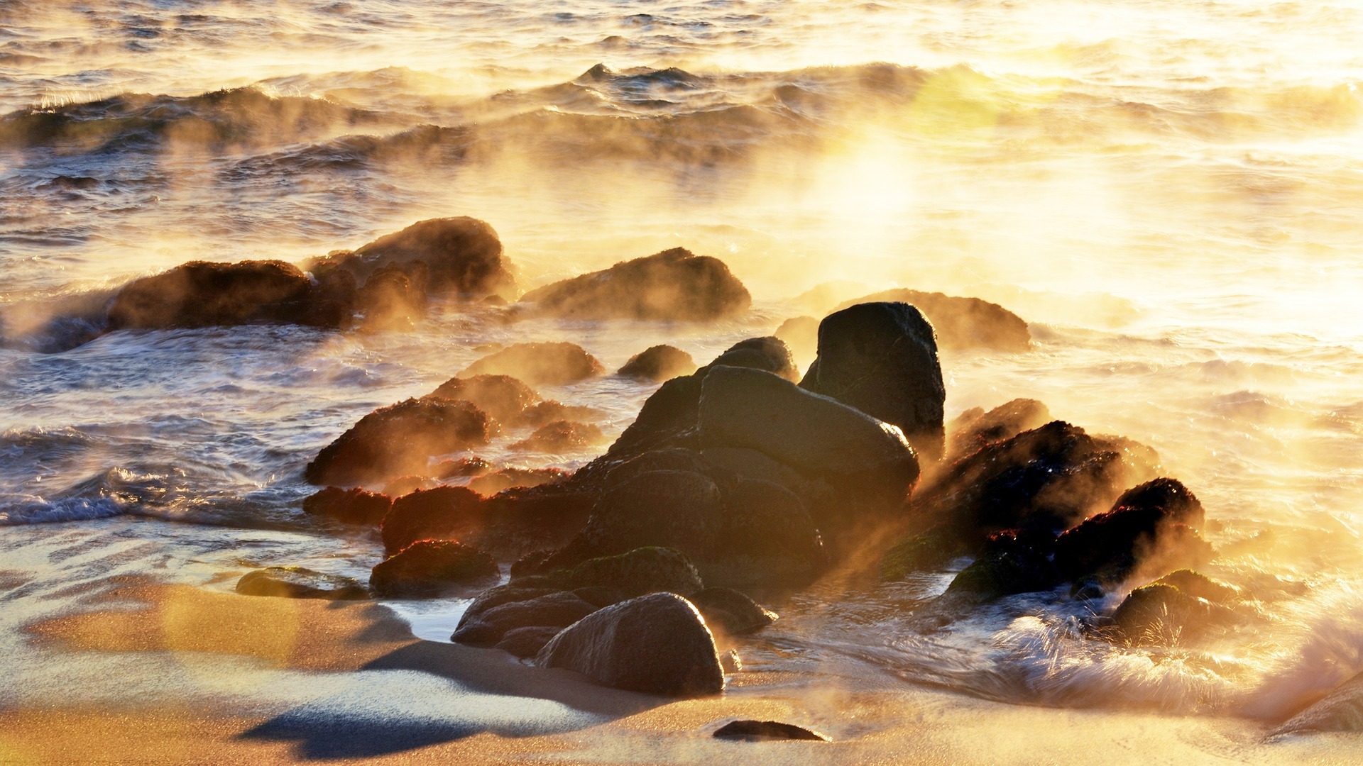 Sea smoke and golden light on coastal rocks HD Wallpaper