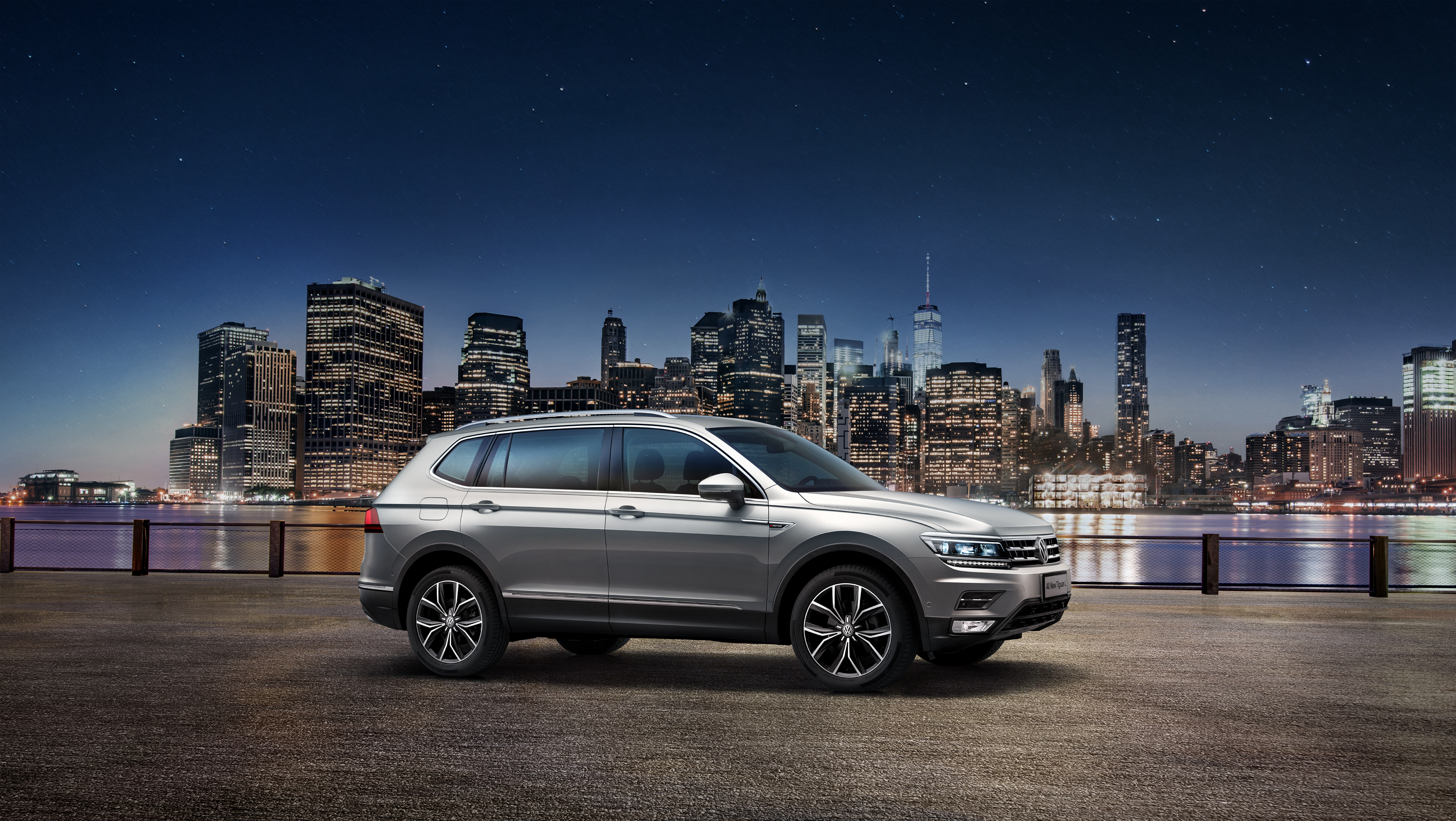 Volkswagen Tiguan L SUV with city skyline at night HD Wallpaper