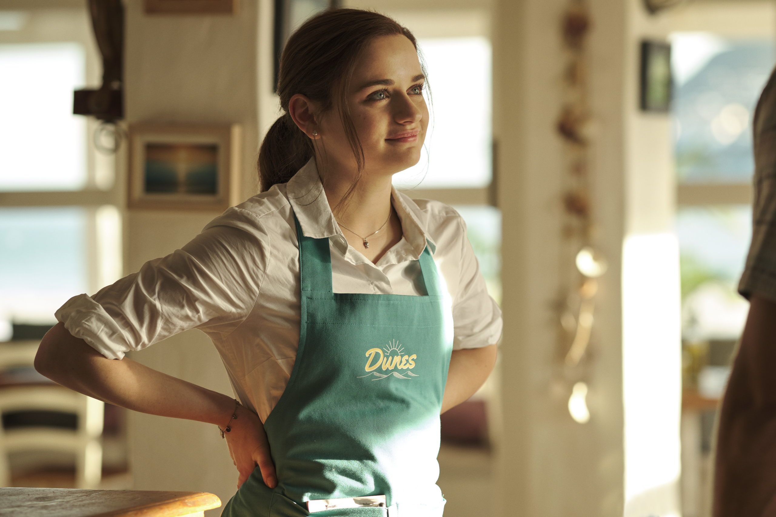 Joey King smiling in a teal 'Dunes' apron HD Wallpaper