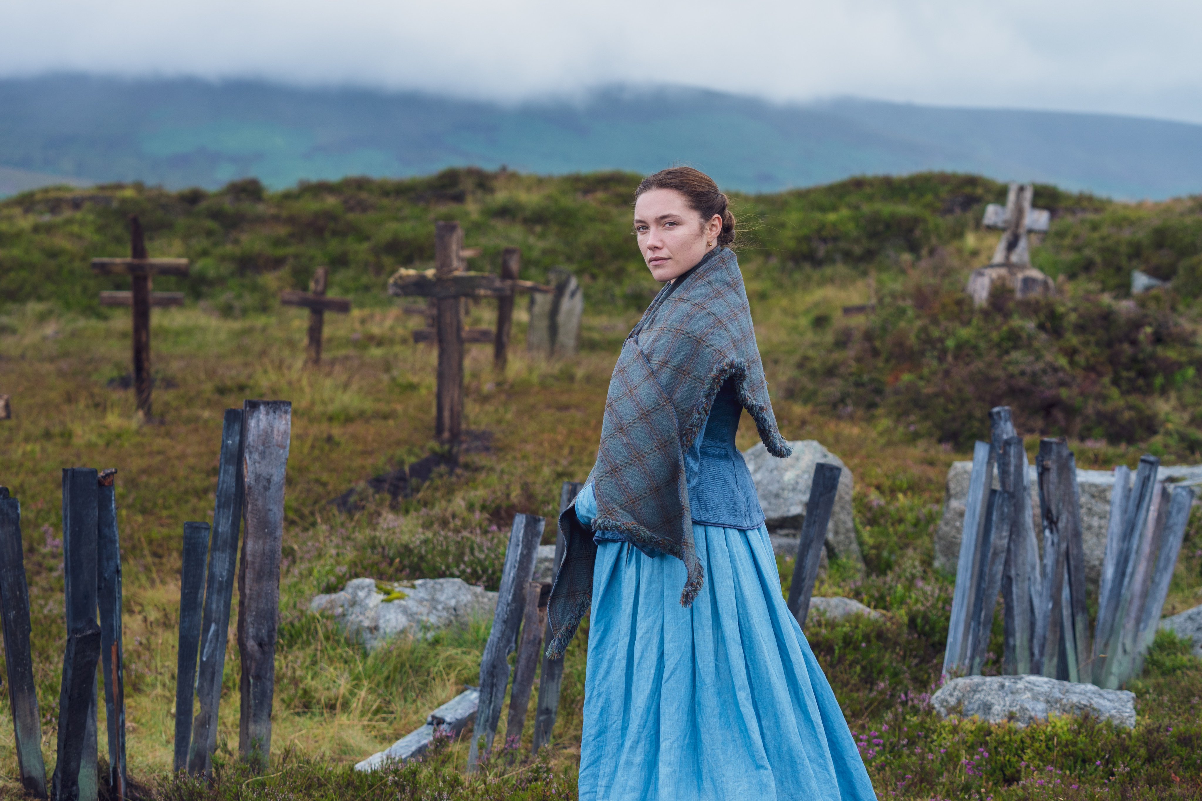 Florence Pugh in a somber landscape with wooden crosses HD Wallpaper