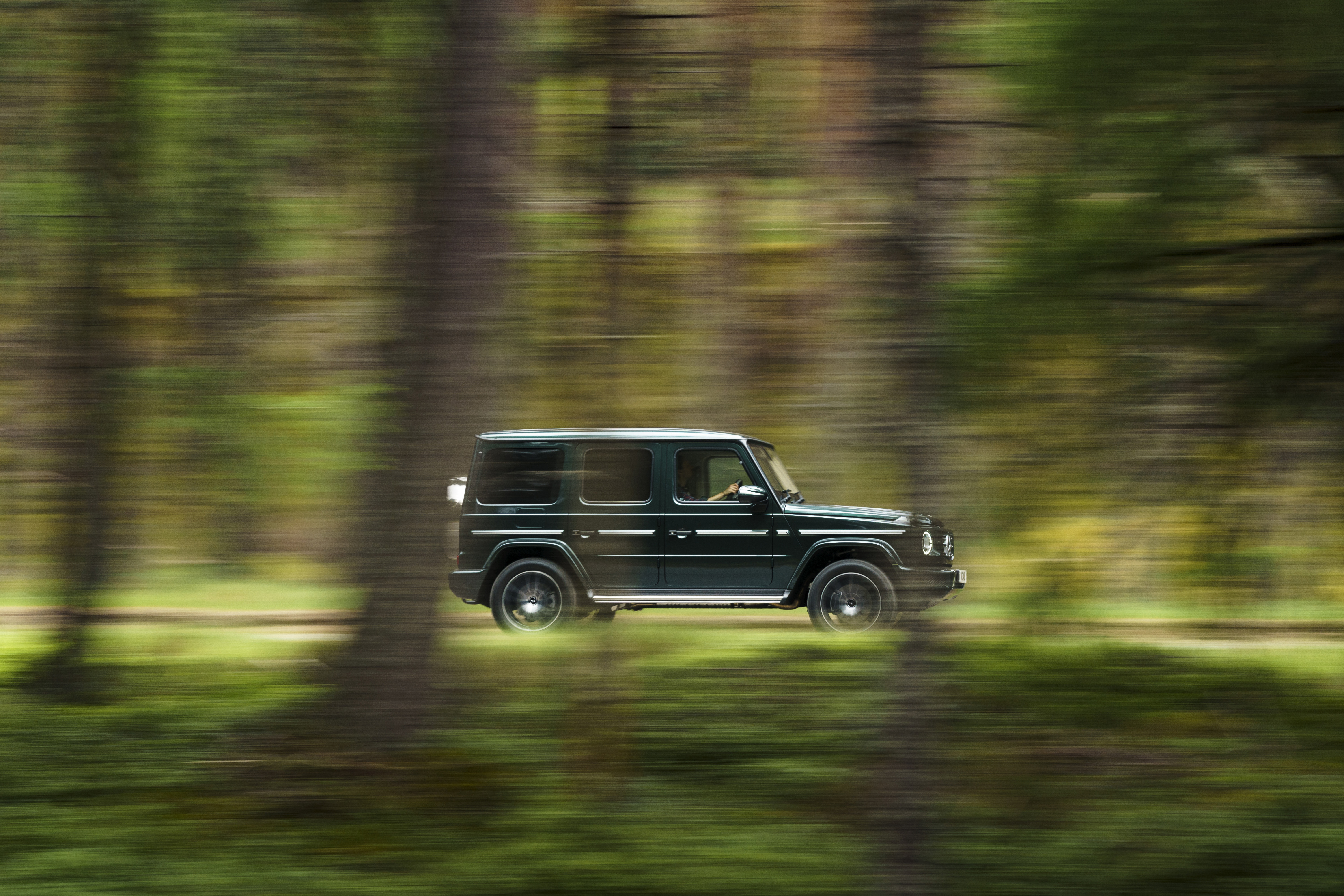 Mercedes-Benz G 400 d SUV speeding through a green forest HD Wallpaper
